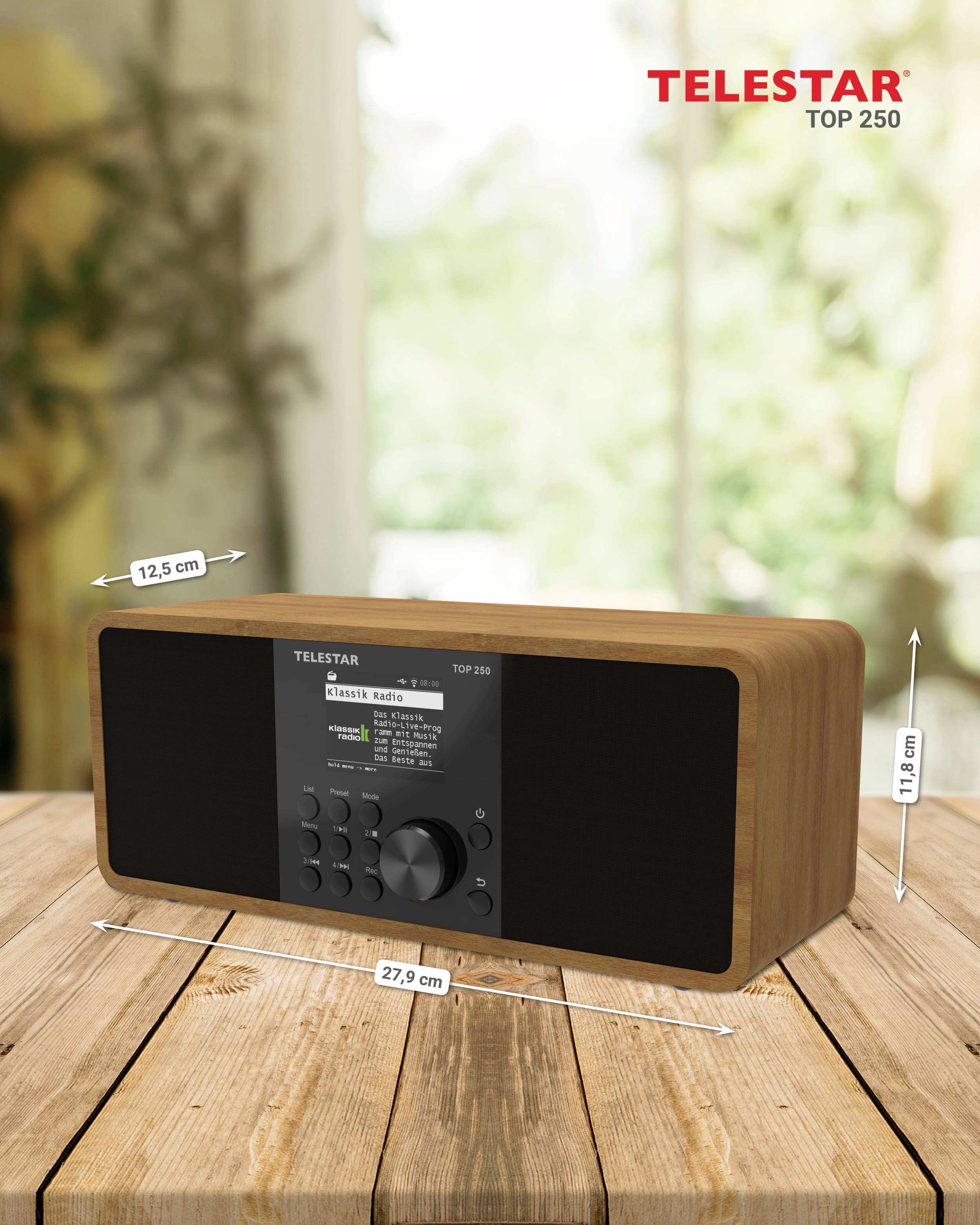 Dřevěné rádio s digitálním displejem a ovládacími tlačítky na dřevěném stole. Rozměry jsou označeny: výška 12,5 cm, šířka 27,9 cm.