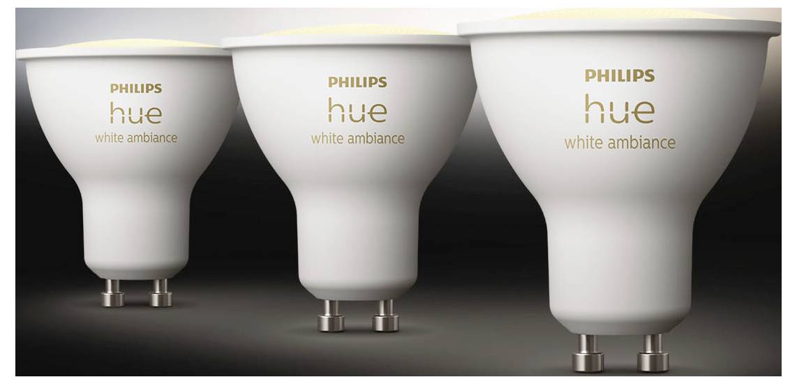 Tři LED žárovky Philips Hue White Ambiance se základnou GU10, umístěné zleva doprava na pozadí s přechodem šedé barvy.
