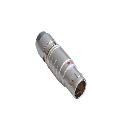 Kulatý kovový konektor s drážkami a červeným bodem, používaný pro elektronické připojení.
