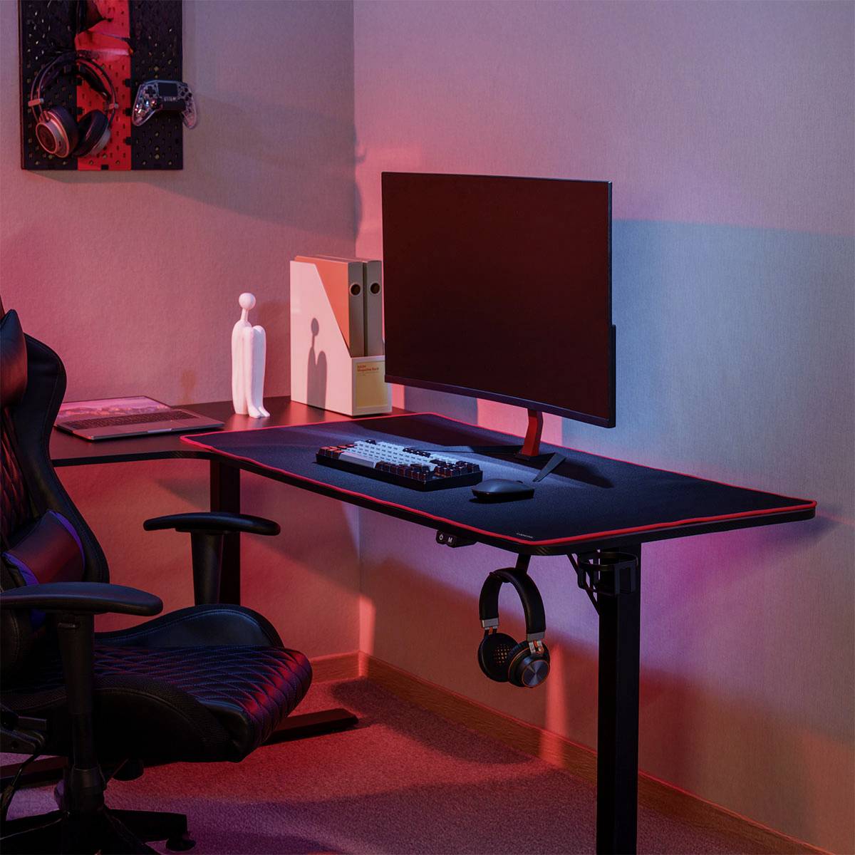 Moderní herní sestava s zakřiveným monitorem na elegantním stole, herní židli, herní headsetu a ambientním RGB osvětlením.