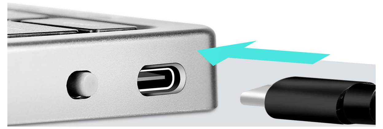 Kabel USB-C zasouvaný do kovového portu notebooku, ilustrující připojení.