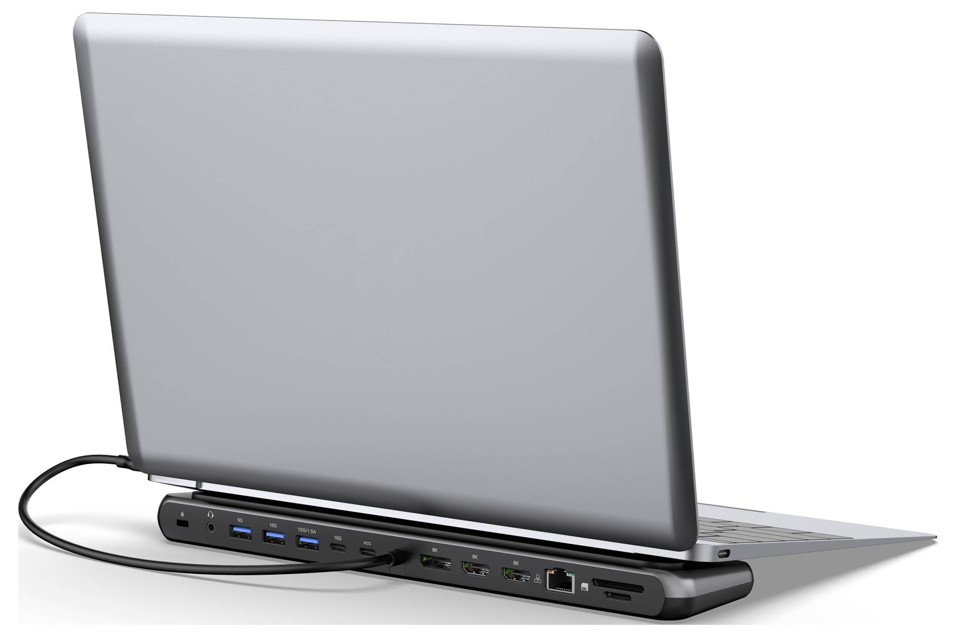 Stříbrný laptop připojený k dokovací stanici s několika porty, včetně USB, HDMI a Ethernetu.