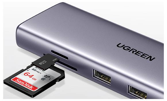 Stříbrný rozbočovač USB značky UGREEN se dvěma USB porty a částečně zasunutou kartou microSD SanDisk s kapacitou 64 GB, který zvýrazňuje funkci slotu pro kartu.