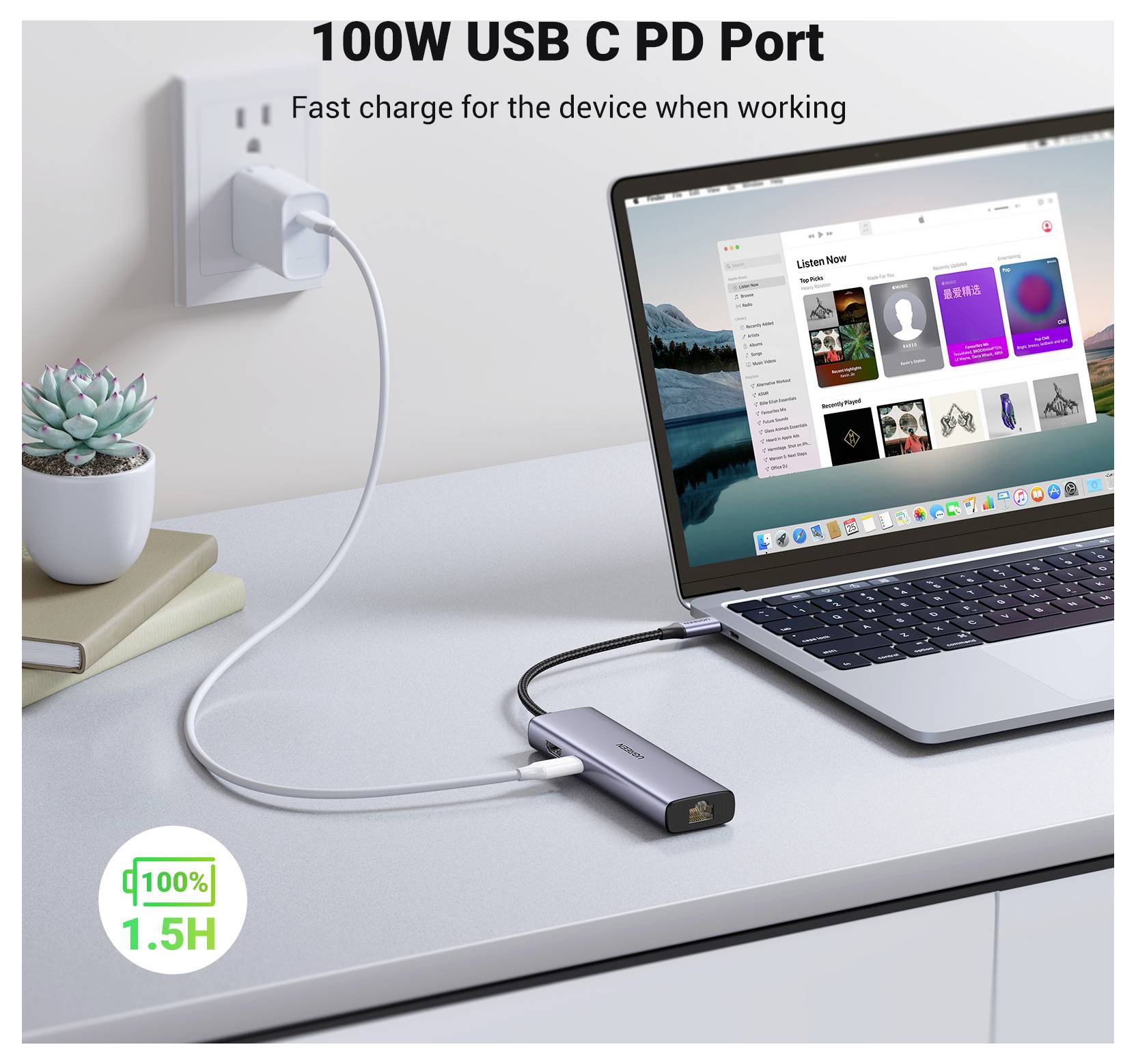Laptop na stole je připojen k elektrické zásuvce prostřednictvím USB-C rozbočovače. Na obrazovce je zobrazený hudební software. Text na obrázku: '100W USB C PD Port'.