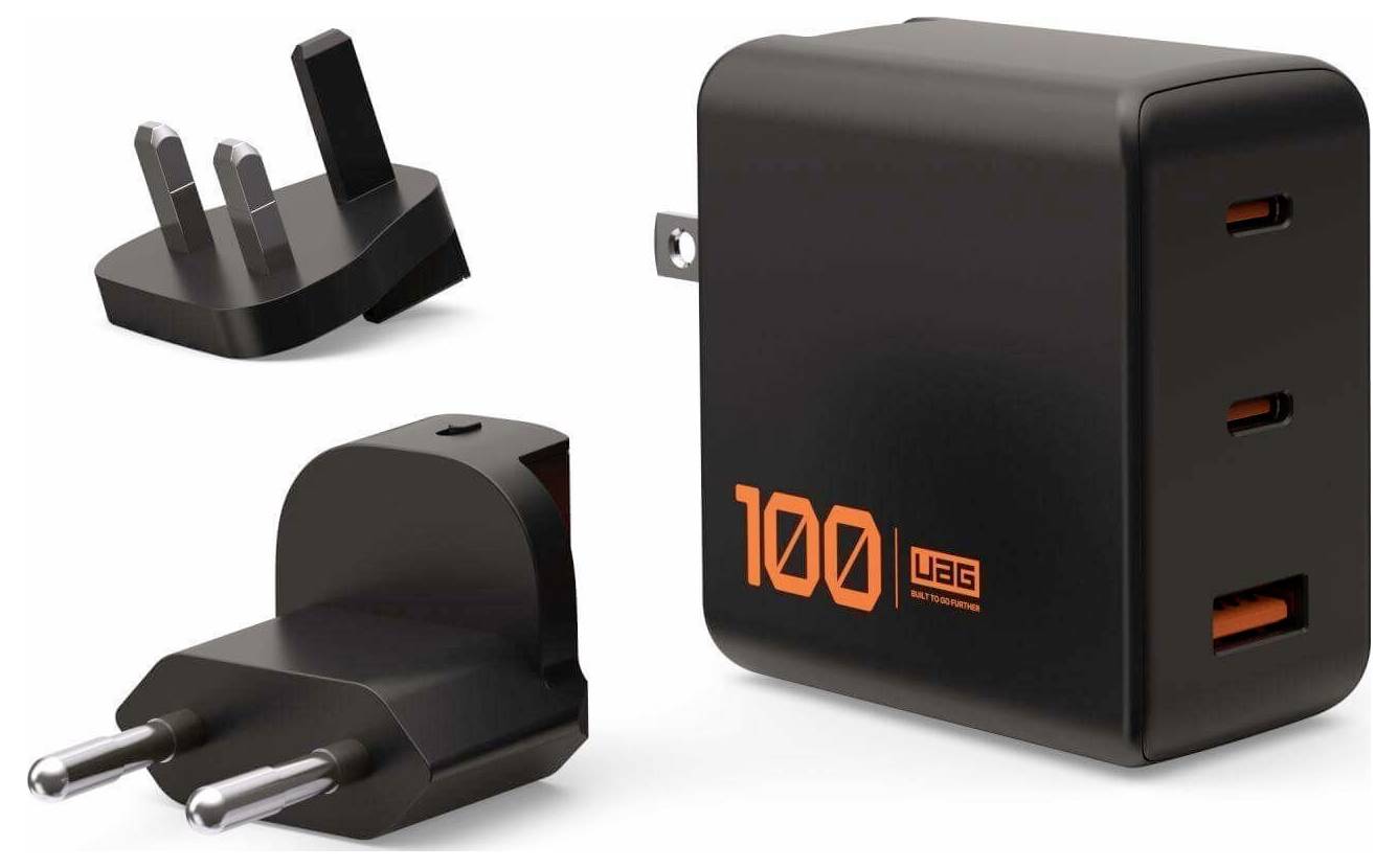 Černá vícenásobná USB nástěnná nabíječka s třemi mezinárodními adaptéry zástrček, která má na nabíječce vytištěný oranžový text '100' a 'uag'.
