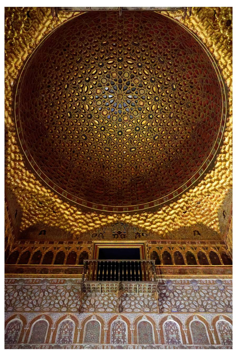 Bohatě zdobený kopulový strop s propracovanými geometrickými vzory a sytými barvami, součást historického paláce, odrážející zlatavé světlo.