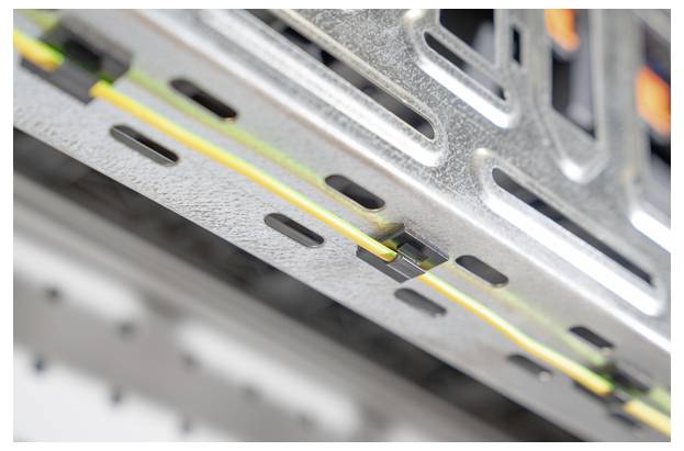 Detailní záběr serverových kabelů upevněných svorkami uvnitř kovového serverového racku, který ukazuje zaměření na správu a organizaci kabeláže.