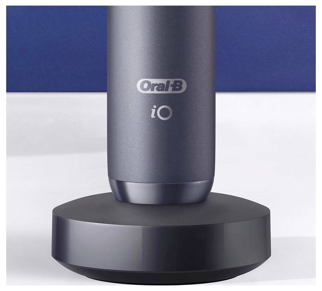 Elektrický zubní kartáček 'Oral-B iO' umístěný na nabíjecí stanici na modrém pozadí.