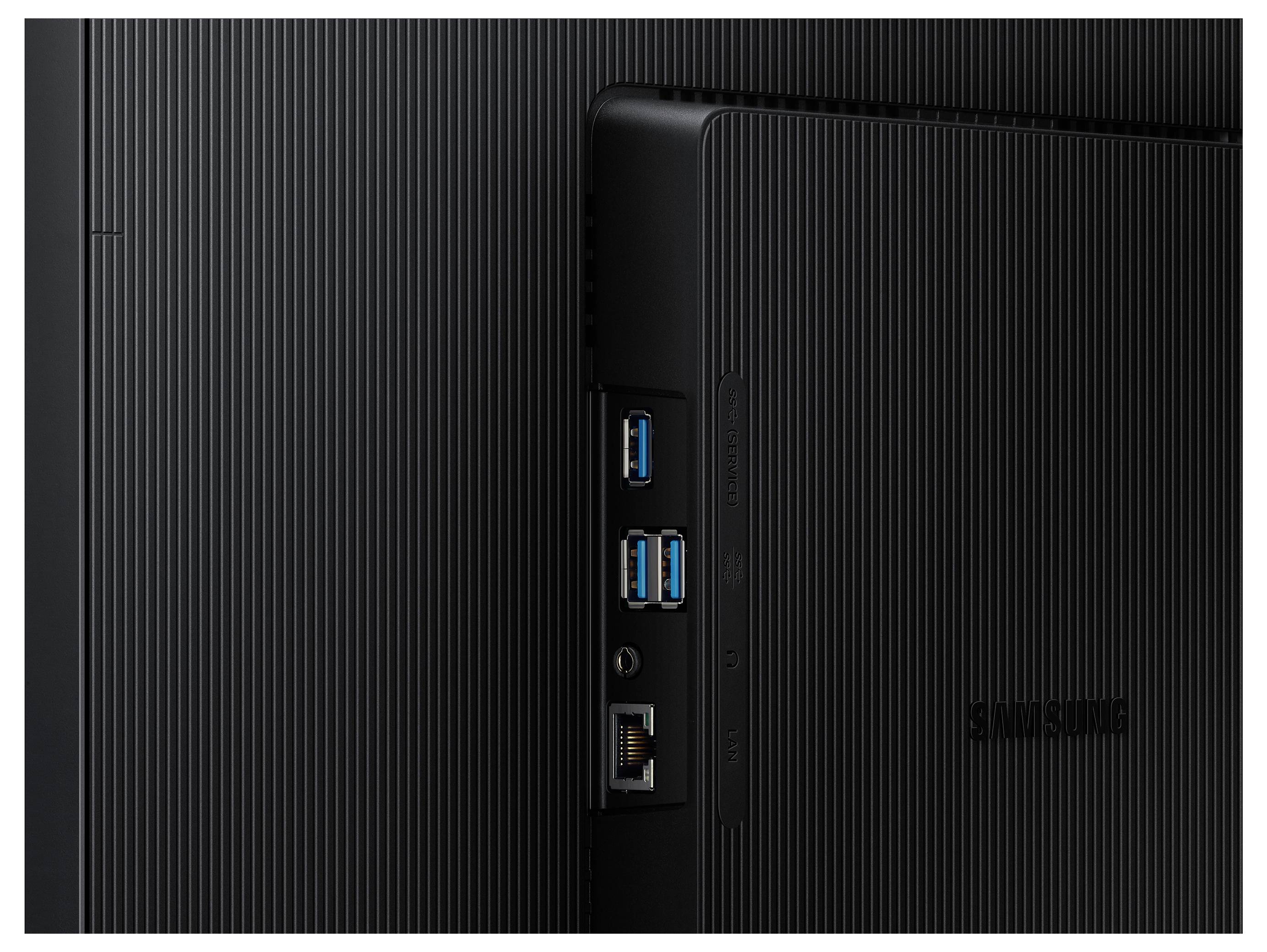 Zadní strana černého elektronického zařízení zobrazující porty, včetně USB a ethernetových připojení, na texturovaném povrchu, viditelné logo Samsung.