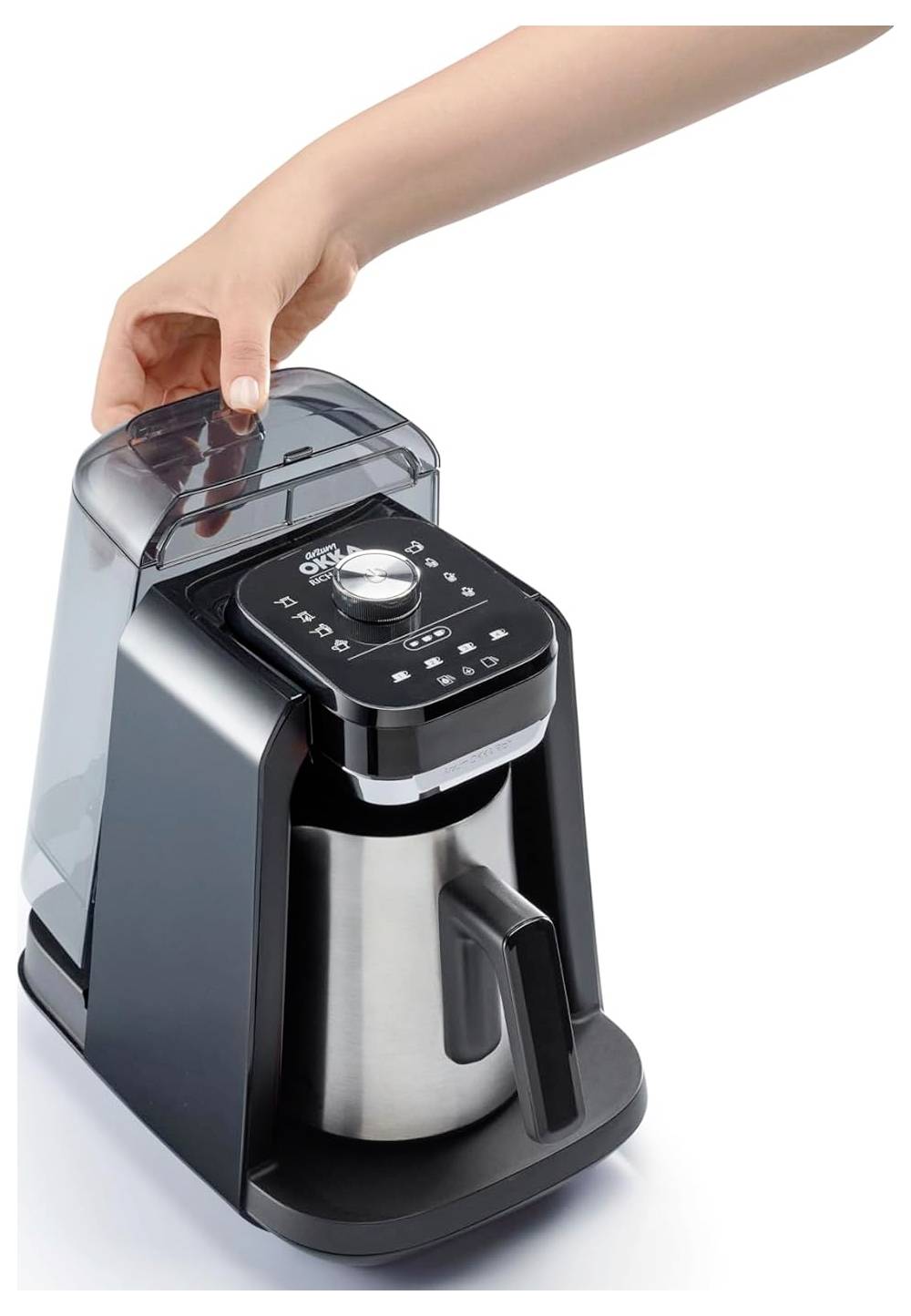 Ruka člověka nasazuje víko na elegantní, moderní kávovar s digitálním displejem a velkou kávovou konvicí.