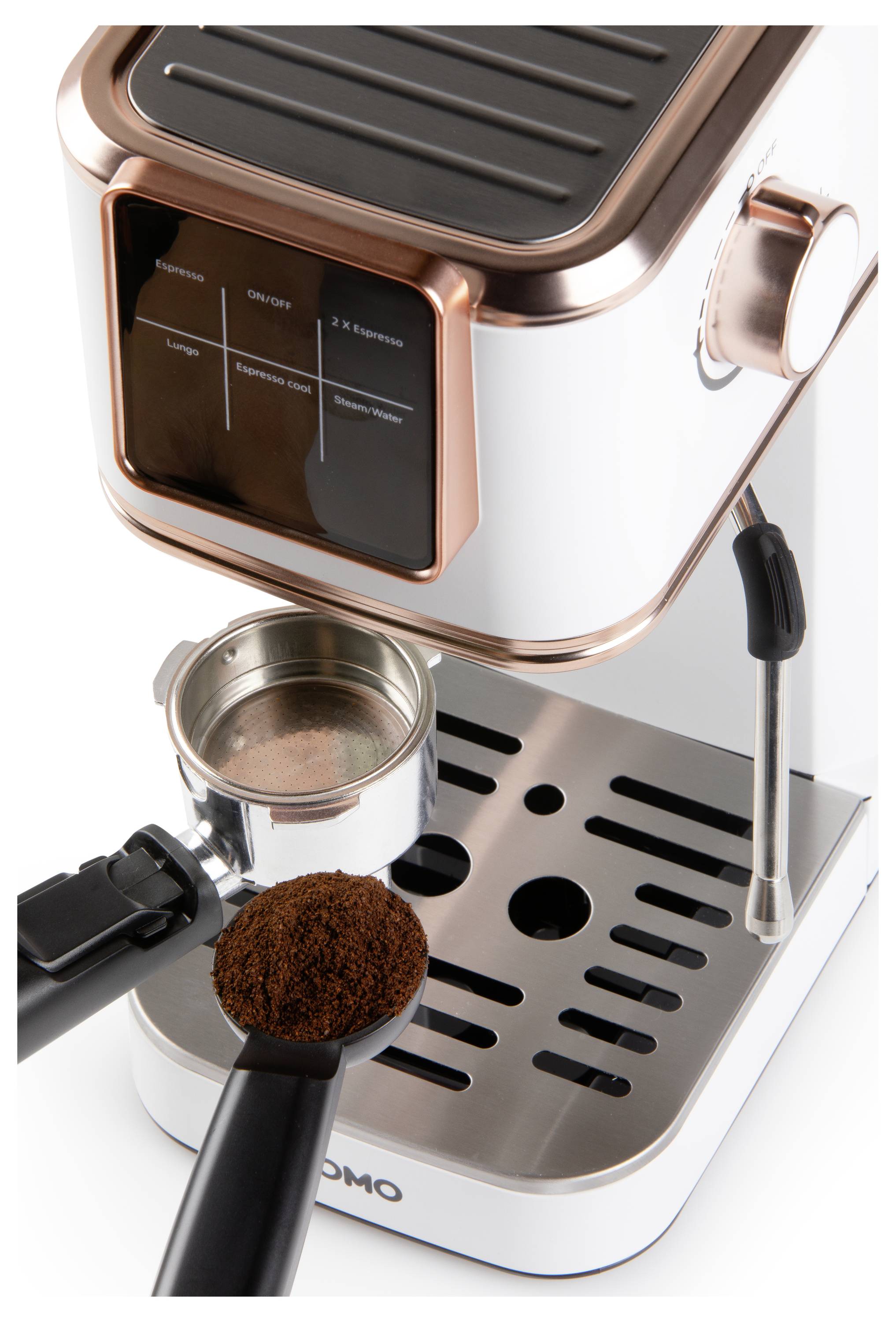 Espresso kávovar s měděnými prvky, zobrazující páku na filtr a lžičku mleté kávy, umístěný na kovovém odkapávači.