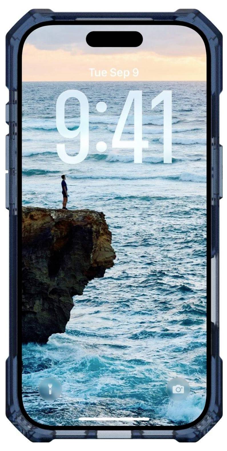 Displej smartphonu zobrazuje tapetu zachycující osobu stojící na okraji útesu, s výhledem na rozlehlý oceán pod oblačnou západní oblohou.