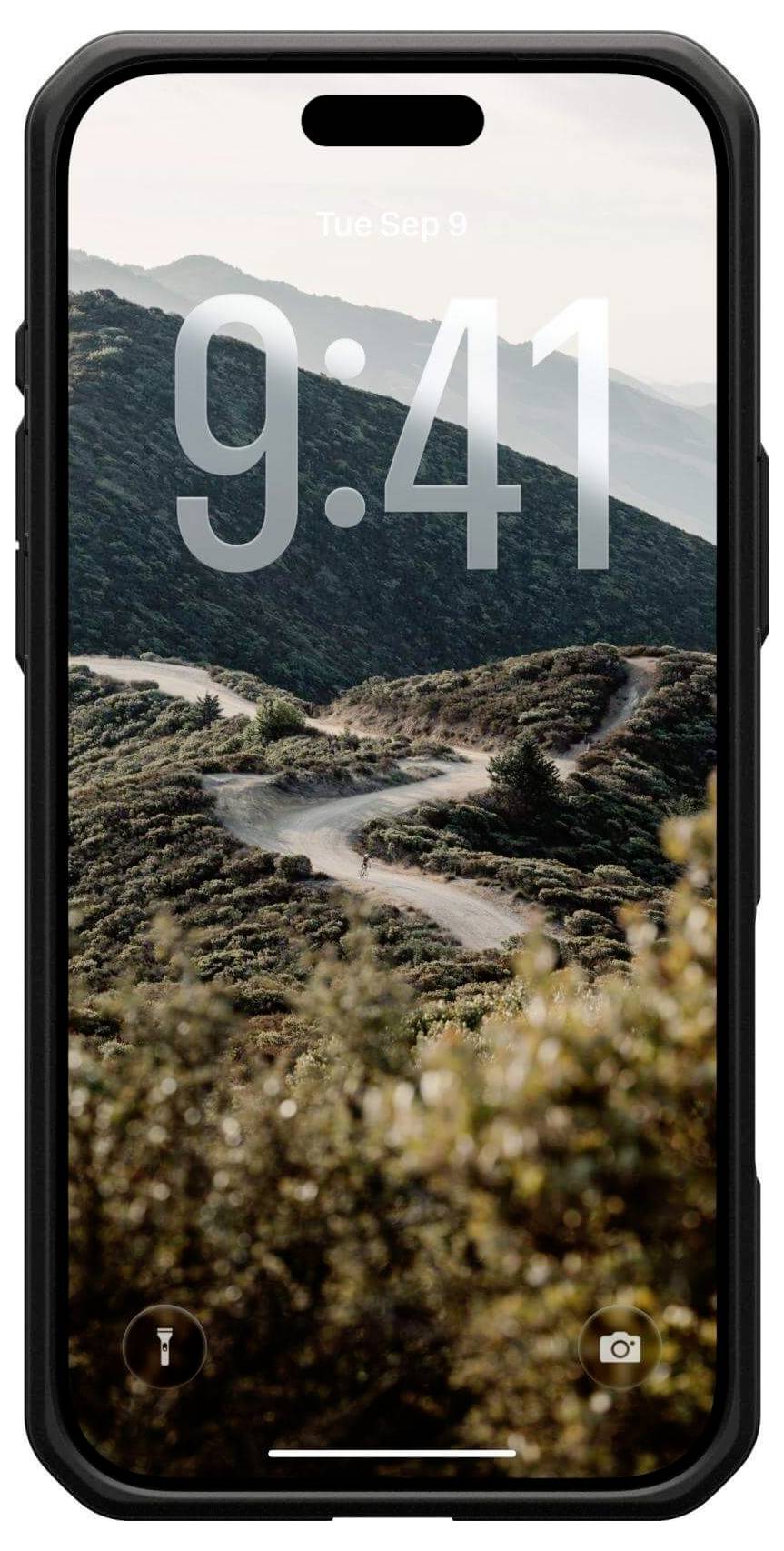 Na smartphonu je zobrazen zamykací displej s časem 9:41 nad scenérií horské silnice, obklopené zelení a jasnou oblohou.