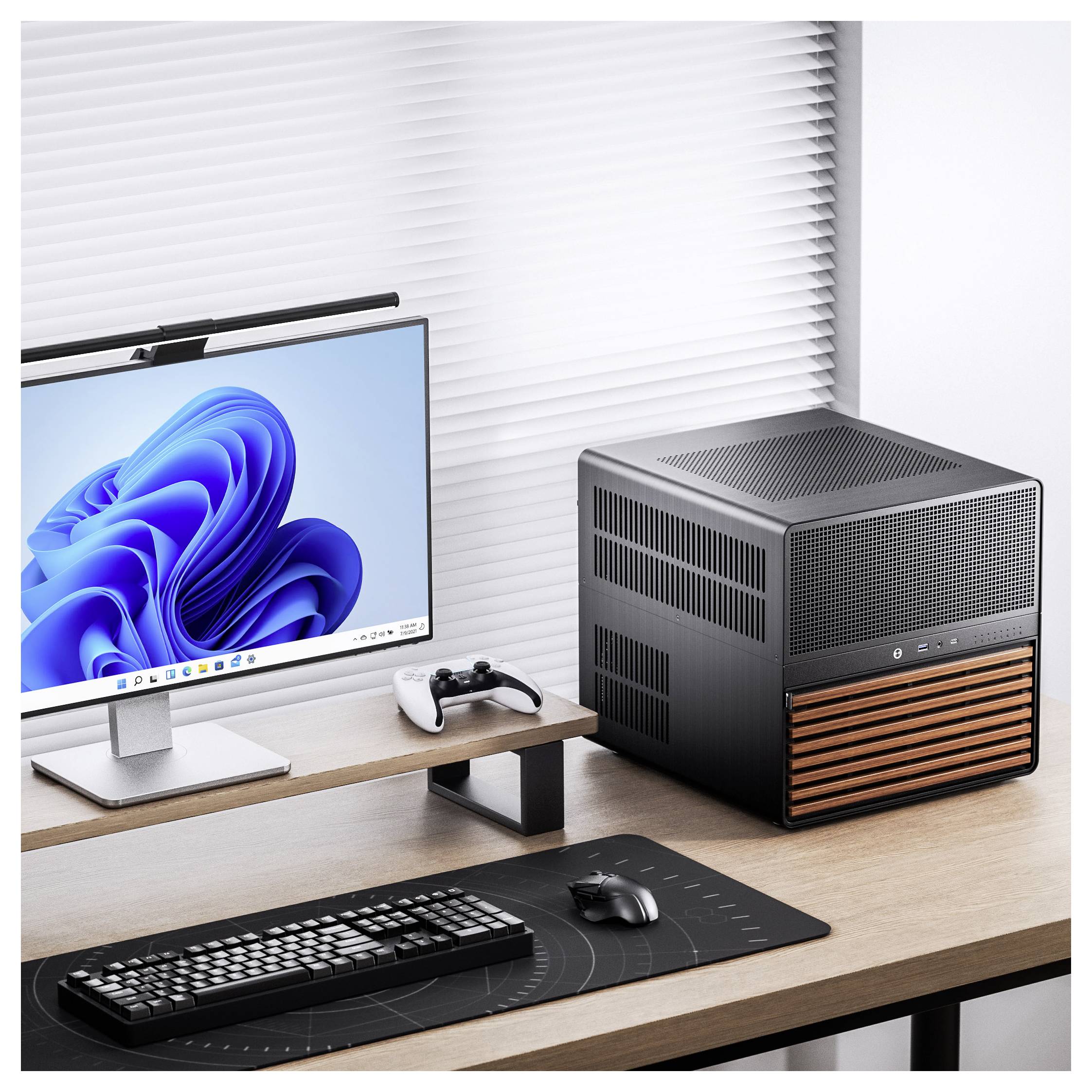 Moderní stolní sestava s monitorem zobrazujícím modrou spirálovitou grafiku, mechanickou klávesnicí, myší, ovladačem a elegantním černým počítačovým pouzdrem s dřevěnými prvky na dřevěném stole.