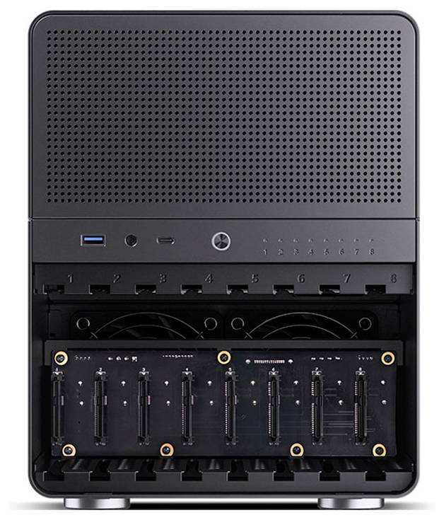 Černé technologické zařízení s otvory pro komponenty, pravděpodobně počítačový server nebo úložná jednotka. Na přední straně jsou viditelné prázdné sloty a tlačítka.