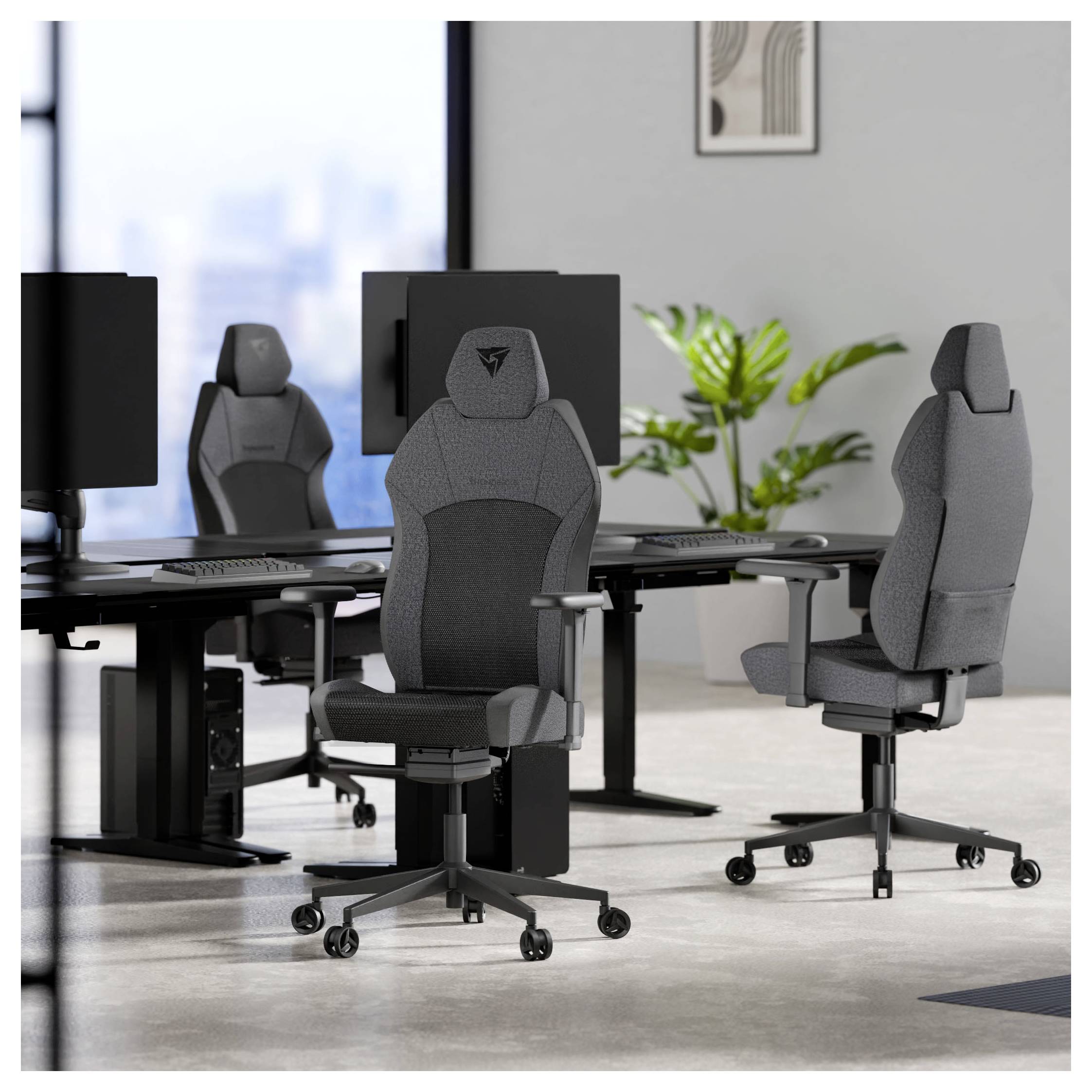 Kancelář s ergonomickými herními židlemi umístěnými proti počítačovým stolům. Dva stoly jsou vybaveny monitory; jedna židle je umístěna uprostřed a ukazuje svůj design.