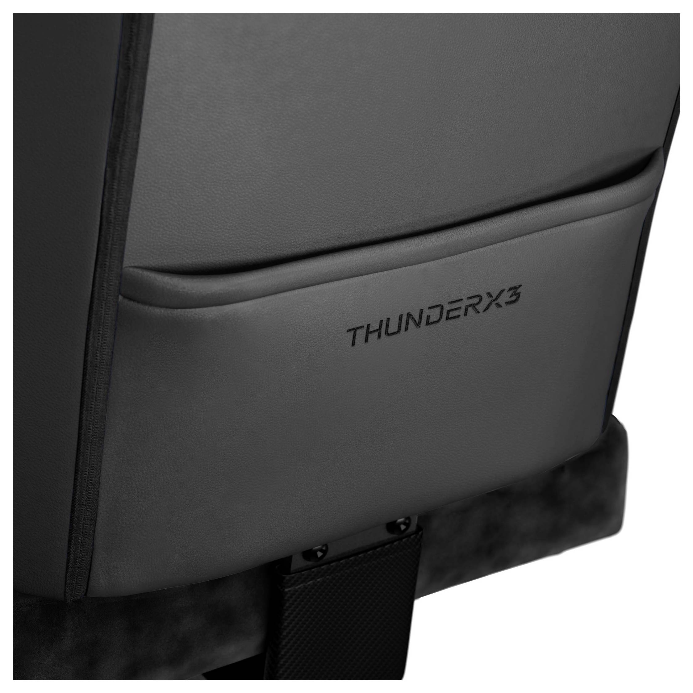 Detailní záběr tmavého čalouněného křesla s textem 'THUNDERX3' vyšitým na opěradle, který ukazuje jeho elegantní a moderní design.