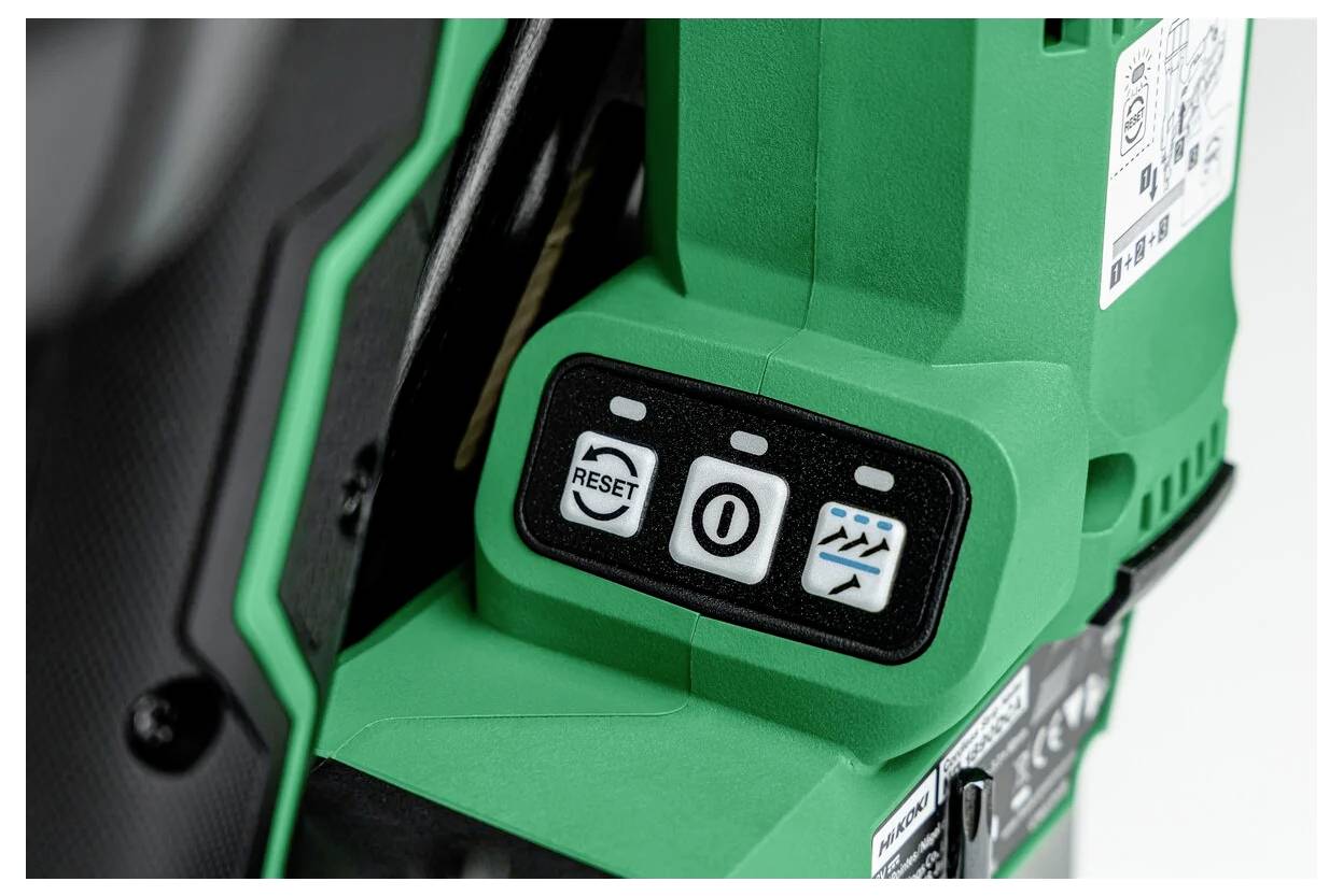 Detailní záběr zeleného elektrického nástroje se třemi tlačítky s popisky „Reset", „0" a „Symbol vlny", který zvýrazňuje jeho ovládací panel.