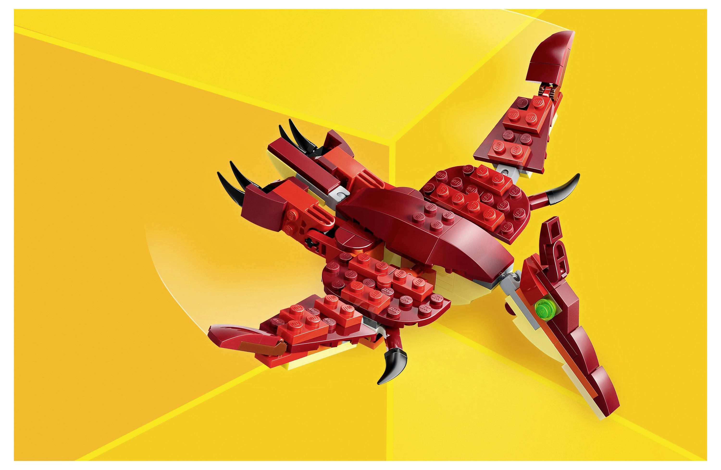 Červeno-žlutý LEGO model draka s rozepjatými křídly, vystavený na jasně žlutém pozadí.