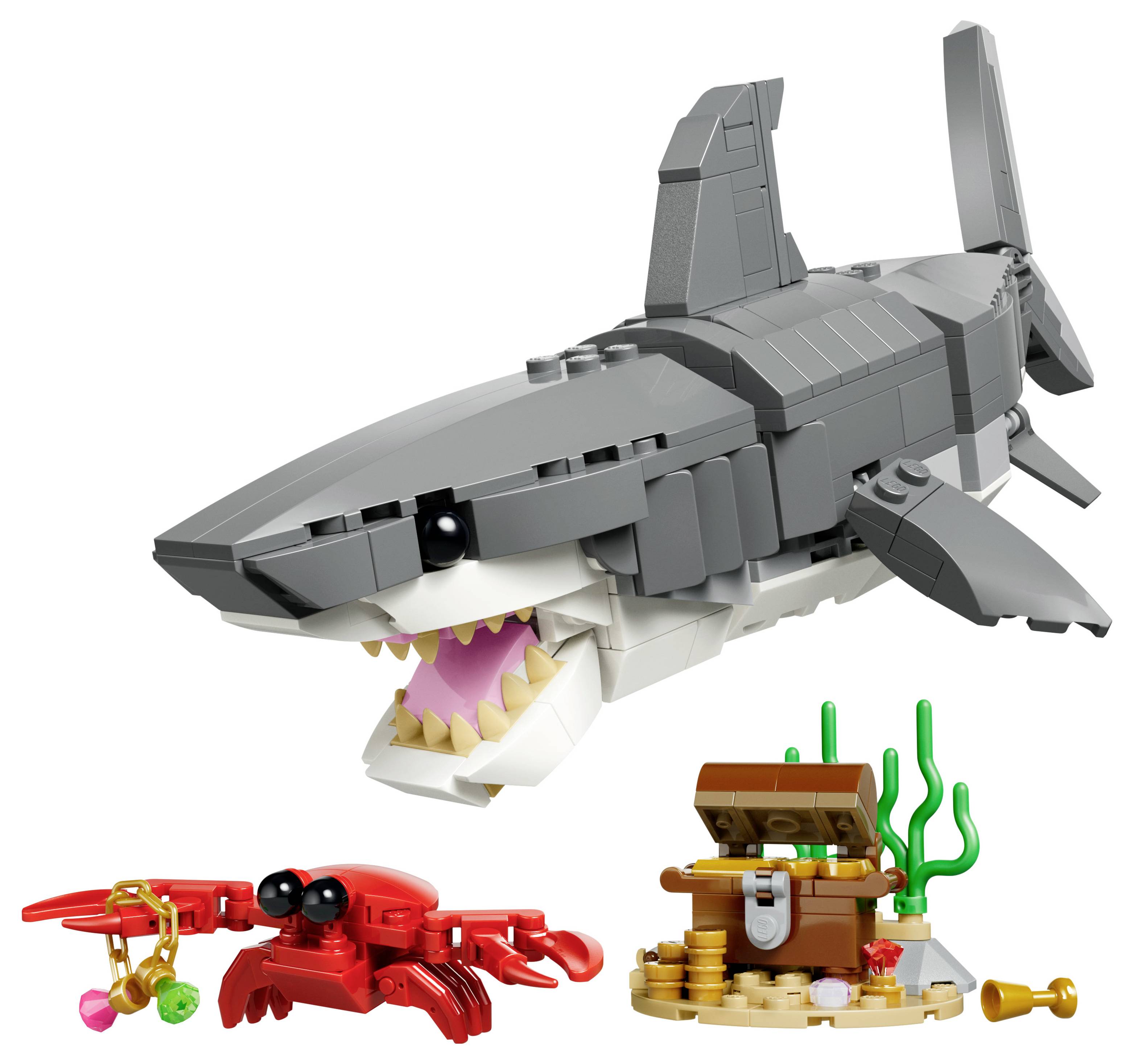 Sada LEGO hraček zobrazující detailní žraloka, červenou krabi držící růžový předmět a pokladnici s mincemi a mořskými řasami.