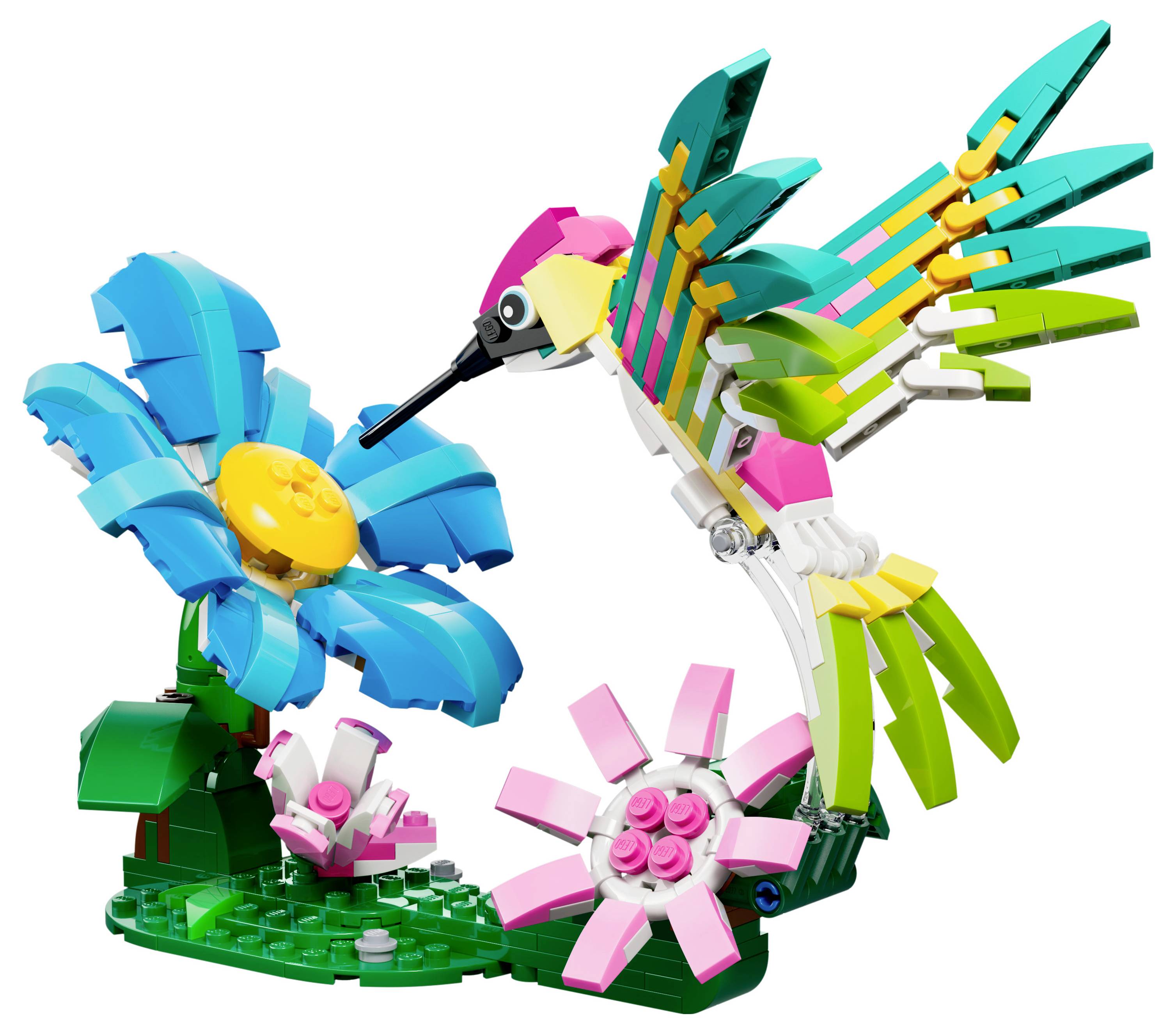 Barevný model LEGO znázorňující kolibříka v růžových, zelených a žlutých tónech, jak se živí z modého květu s žlutým středem.