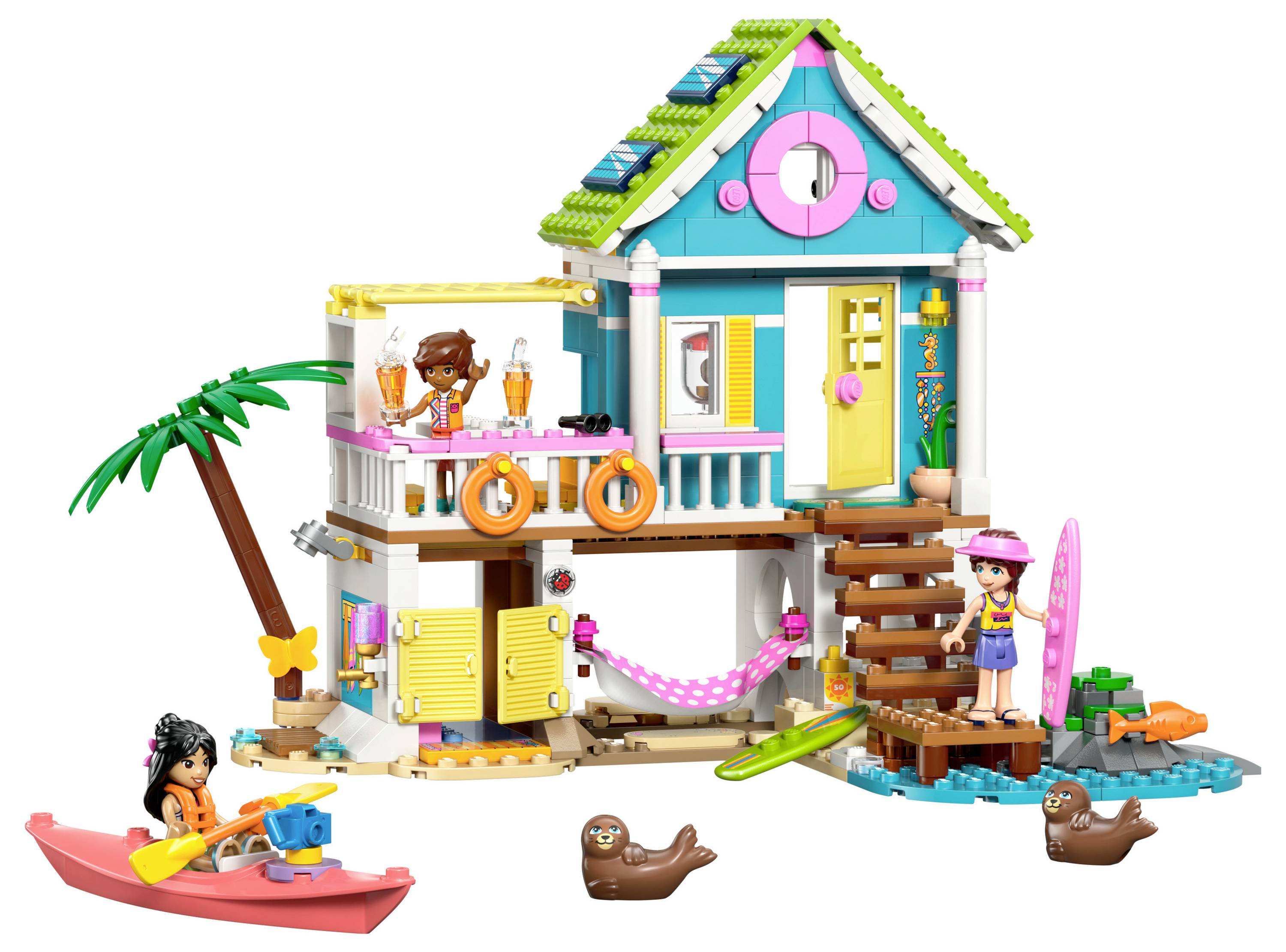 Sada hraček s domkem ve stylu dvoupatrového designu v pestrobarevném provedení, s palmovým stromem a kajak. Obsahuje malé figurky, surfové prkna a hravá zvířata.