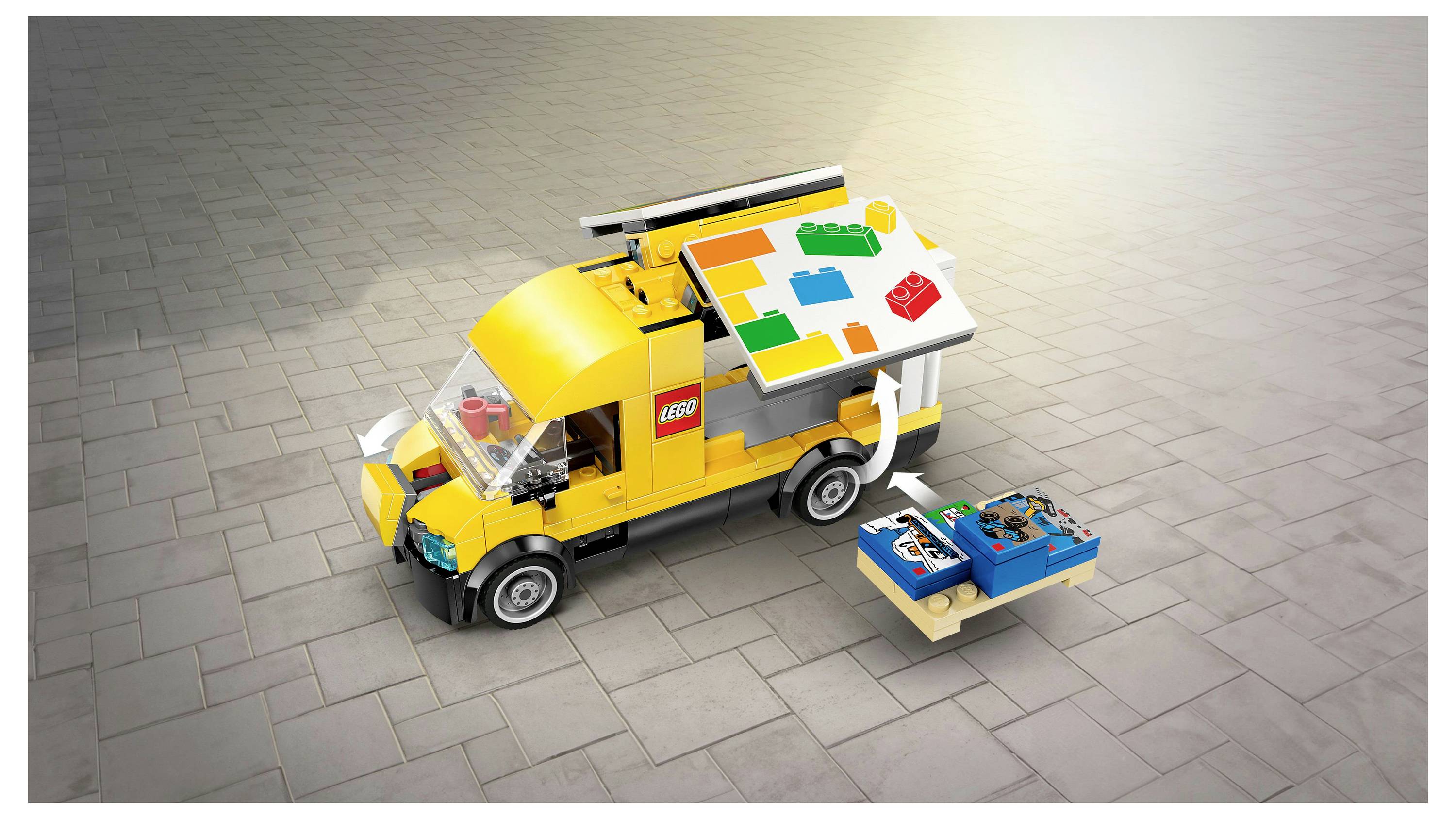 Žlutý dodávkový vůz LEGO s barevnou nabídkou na střeše a malým vozíkem vedle něj, umístěný na dlážděném povrchu, což naznačuje mobilní stravovací službu.