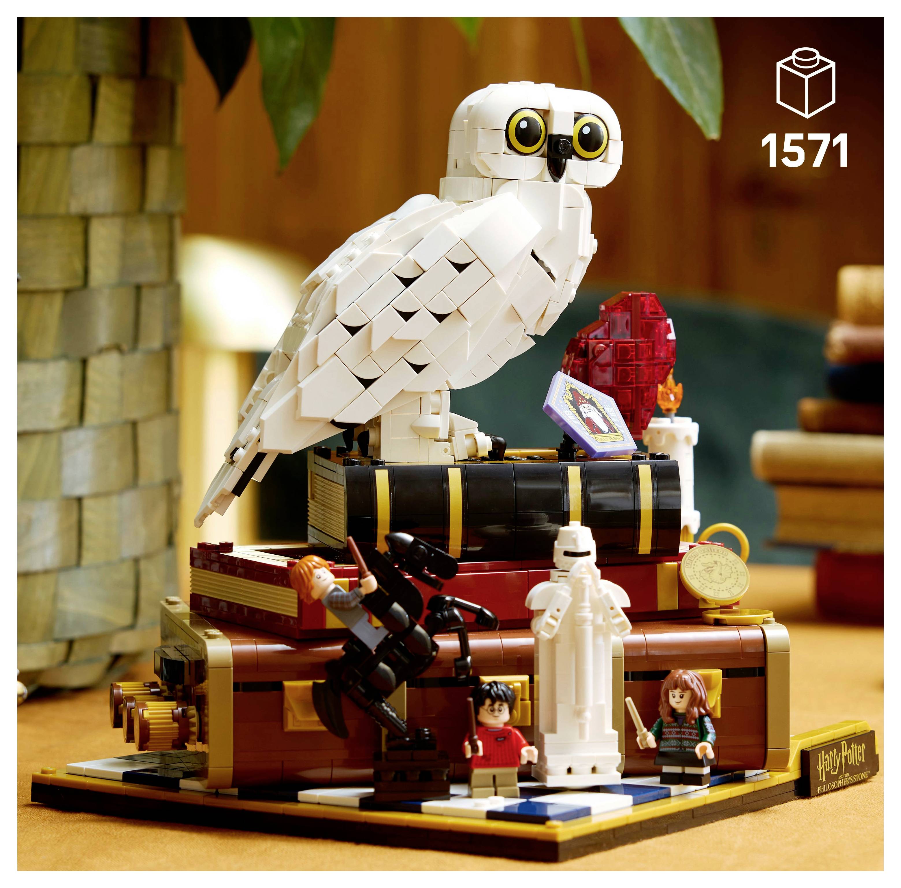 Sada Lego zobrazující sovu na stohu knih s postavami držícími hůlky. Na krabici je uvedeno 1571 dílků, téma 'Harry Potter'.