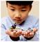 Dítě drží LEGO soupravu s malou figurkou v brnění a zelenou figurkou, obě připomínající postavy z populární sci-fi série.