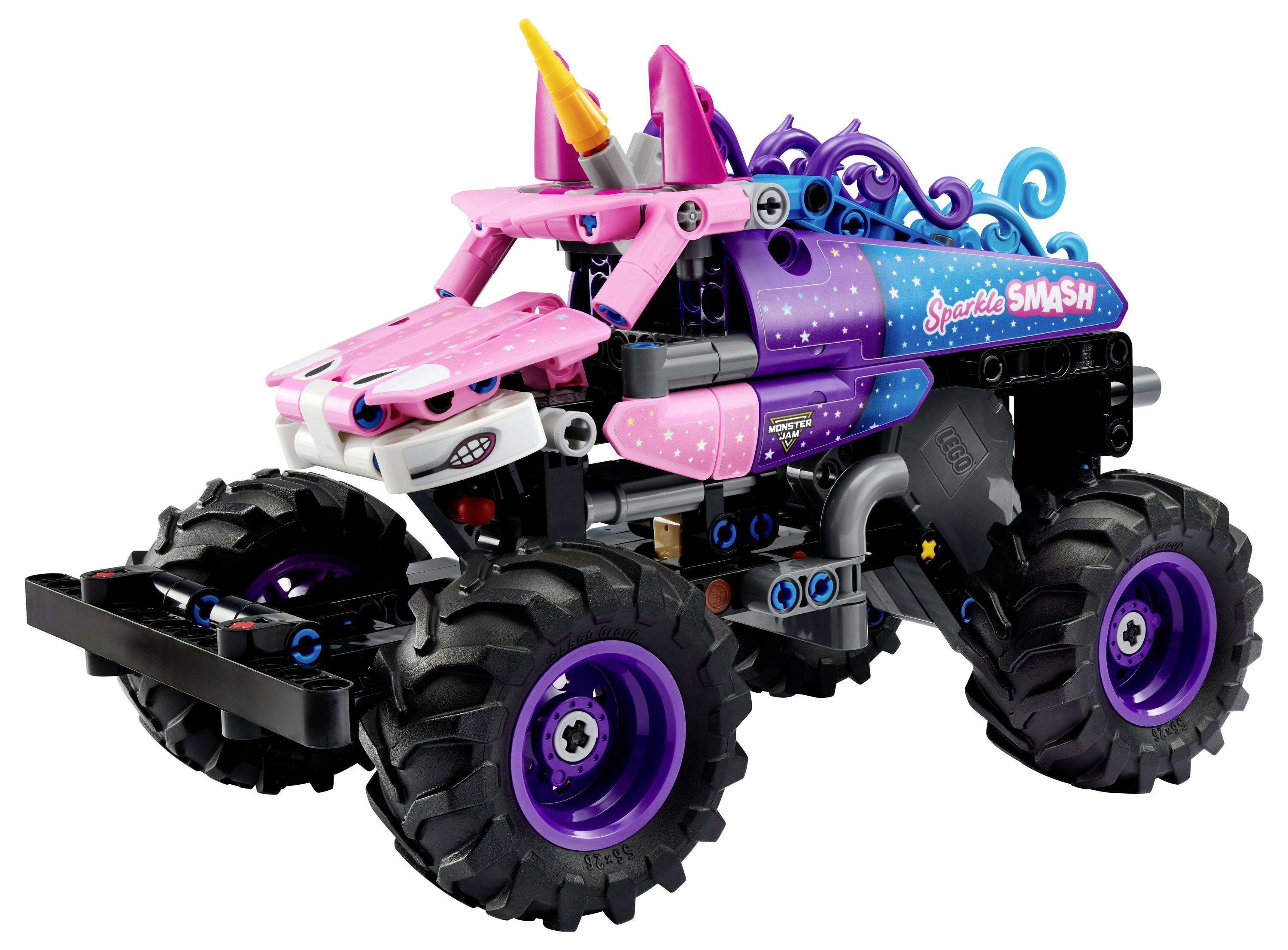 Hračkářský monster truck s velkými černými pneumatikami, růžovo-fialovým tělem s víry a jednorožčím rohem vpředu.