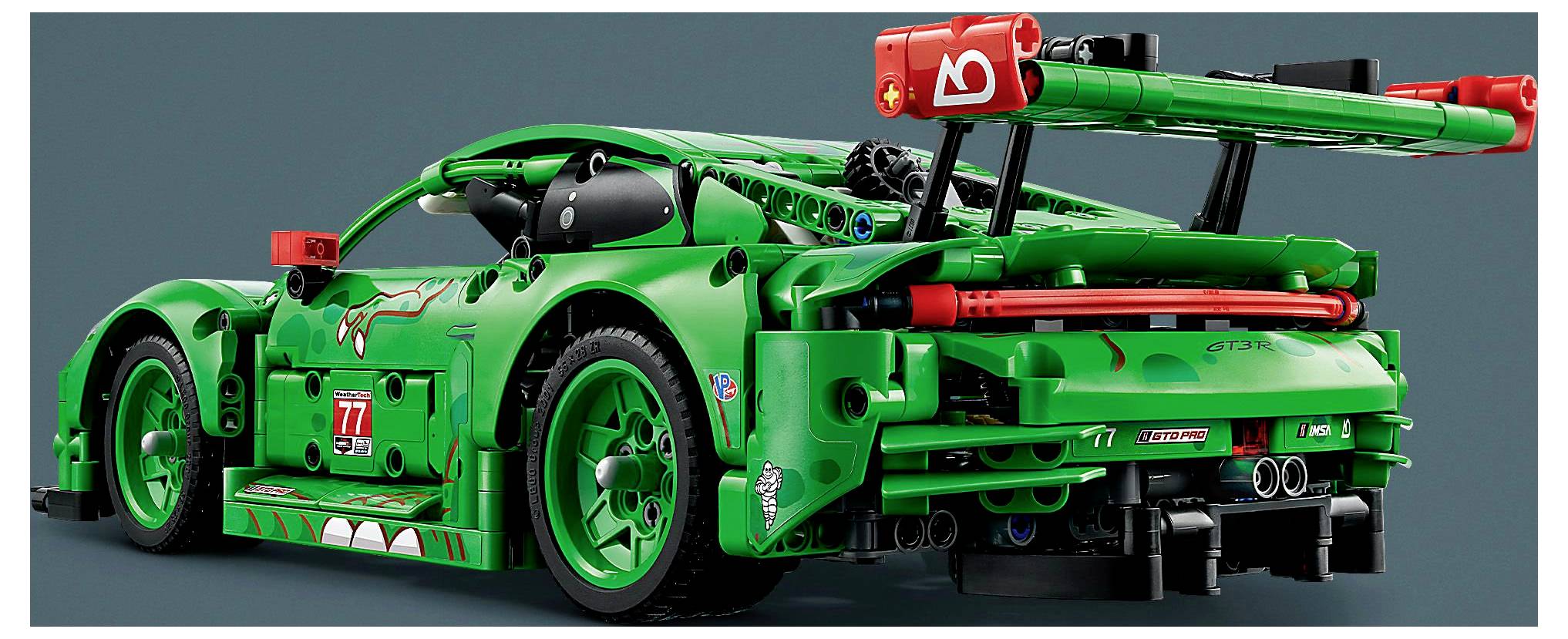 Zelené Lego závodní auto s červenými akcenty, velkým zadním křídlem a viditelnými mechanickými detaily, připomínající vysoce výkonný sportovní vůz.