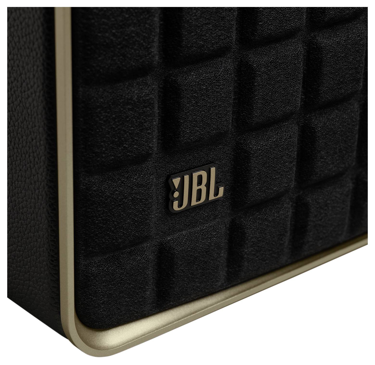 Detail černého reproduktoru JBL s texturovaným mřížkovým vzorem a zlatým logem na přední straně.