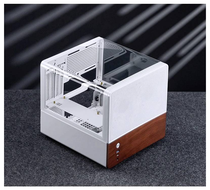 Moderní, krychlovitá skříň počítače s průhledným panelem a dřevěným detailem, prezentující minimalistický a otevřený design na šedém povrchu.