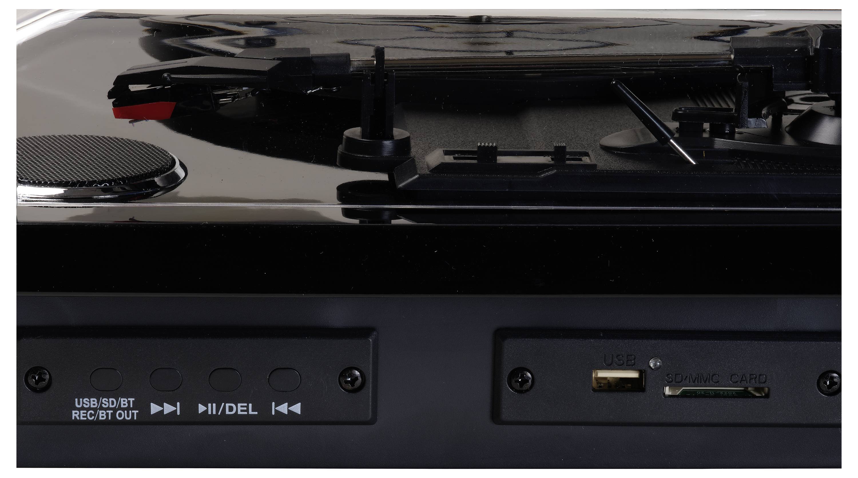 Detailní záběr gramofonu ukazující ovládací tlačítka, USB port a sloty na karty. Lesklý povrch odráží světlo a zvýrazňuje jemné detaily.