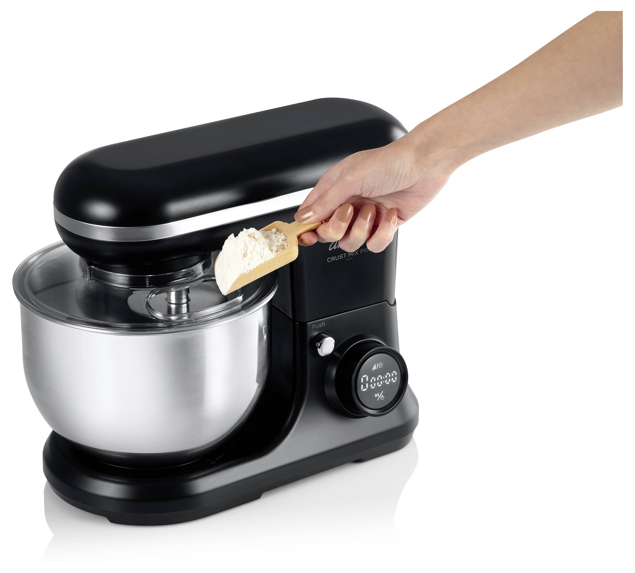 Ruka nabírá mouku do elektrické kuchyňské roboty s kovovým mísením, připravuje ingredience na pečení.