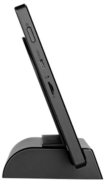 Boční pohled na černý elektronický přístroj v nabíjecí stanici, zobrazující USB porty a tlačítka.