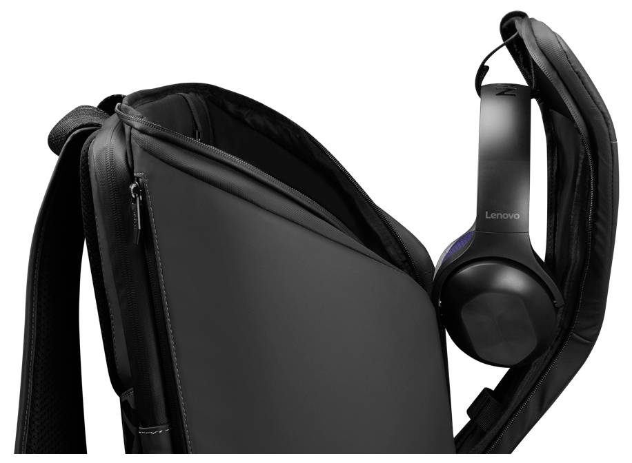 Černý laptop batoh s částečně otevřeným zipem, který ukazuje Lenovo headset zavěšený na straně, zdůrazňující přenositelnost technologií.