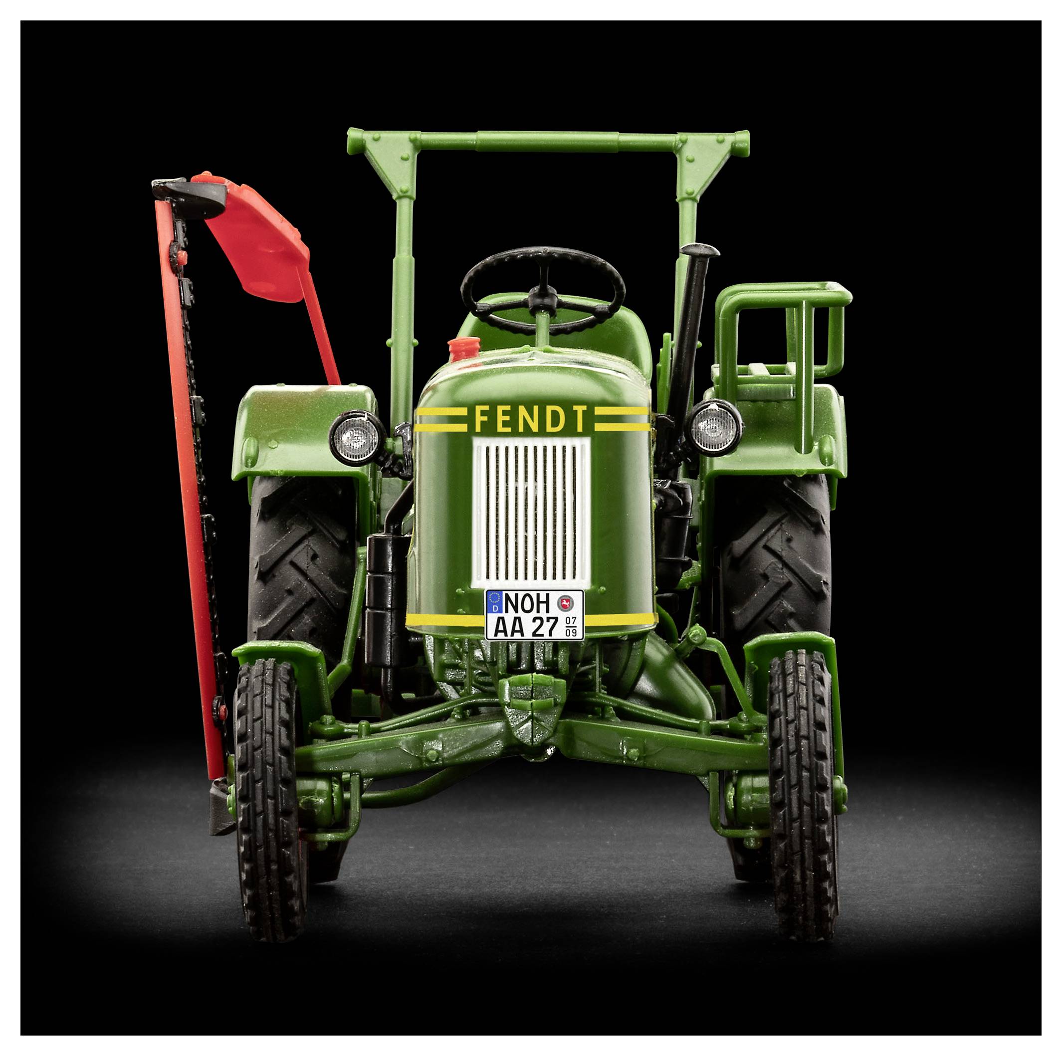 Zelený vintage traktor značky Fendt, pohled zepředu, stojící na tmavém pozadí. Červené akcenty na levé straně, poznávací značka viditelná.