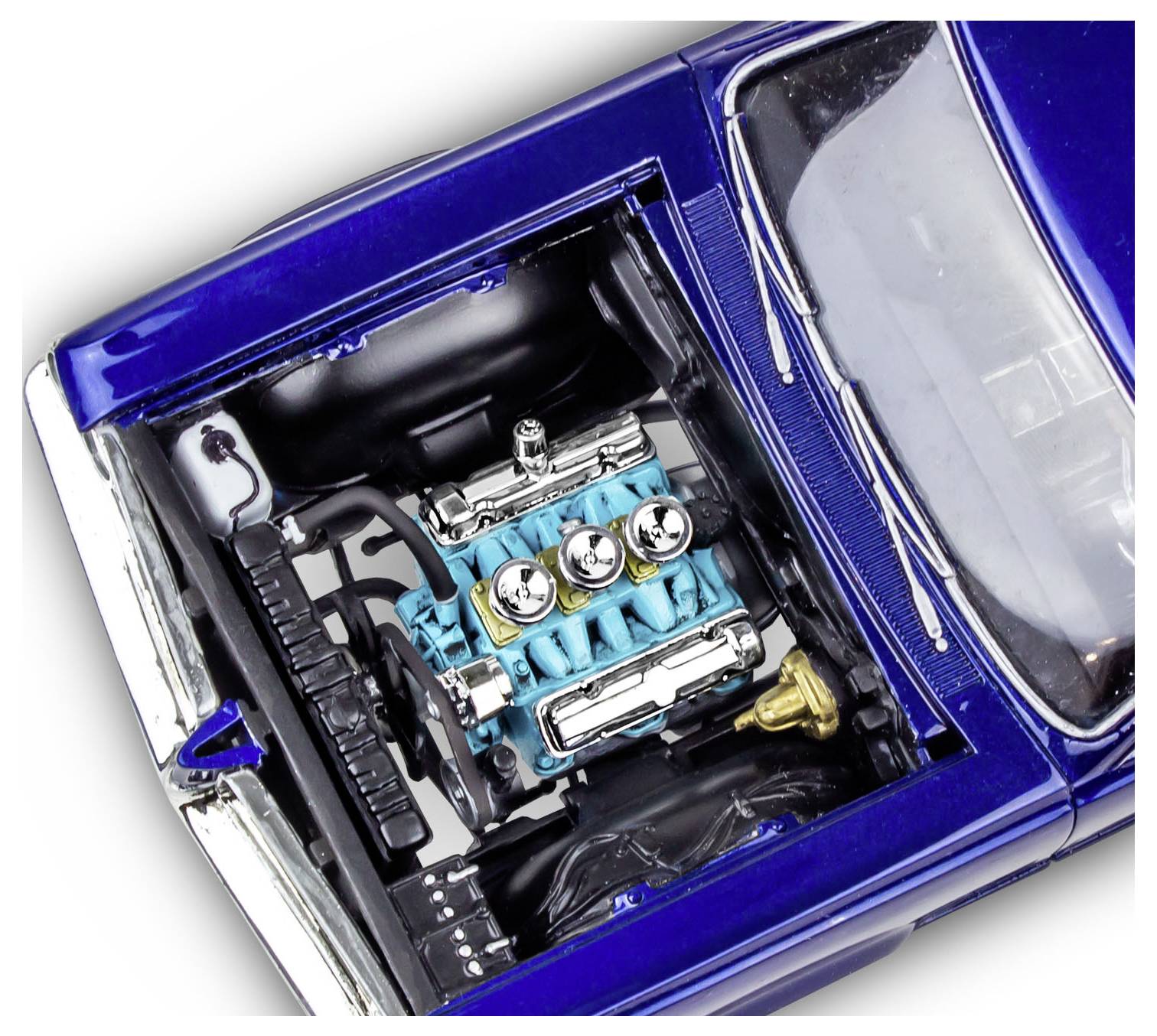 Detailní pohled do motorového prostoru klasického modrého automobilu, zobrazující podrobný tyrkysový motor s chromovanými komponenty a elektrickými vodiči.