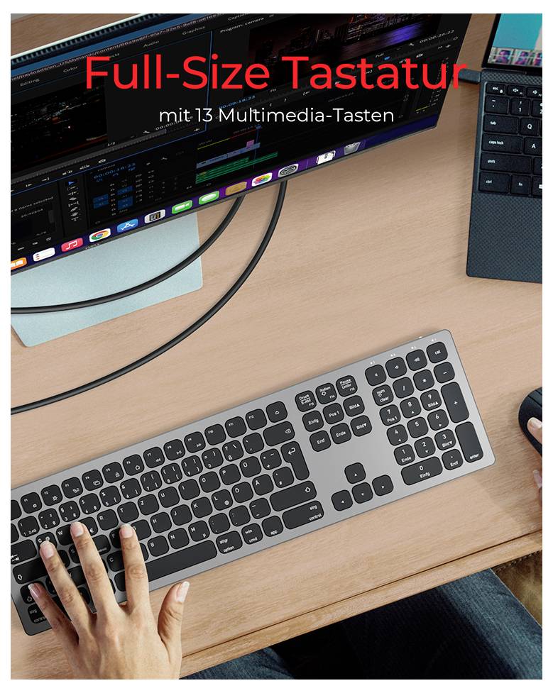 Plnohodnotná klávesnice s 13 multimediálními klávesami ležící na psacím stole, vedle ní myš a dva monitory s otevřeným softwarem.