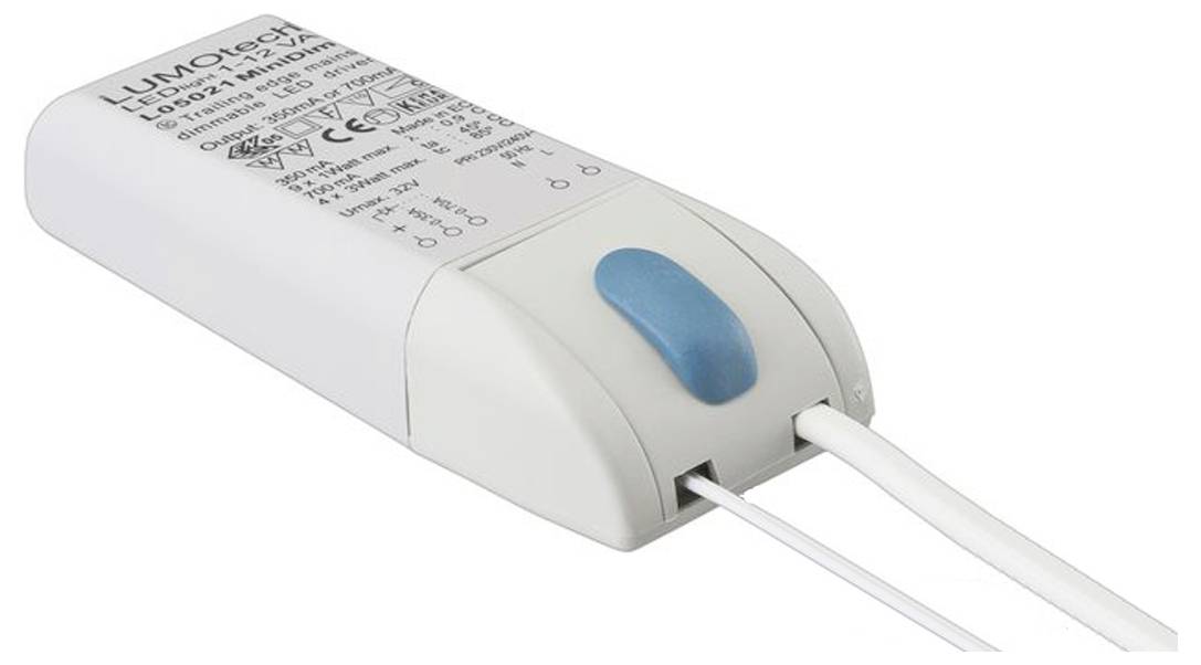 Malé bílé elektronické zařízení s modrým tlačítkem a vodiči, na jehož povrchu jsou vyznačena upozornění a specifikace napájení.