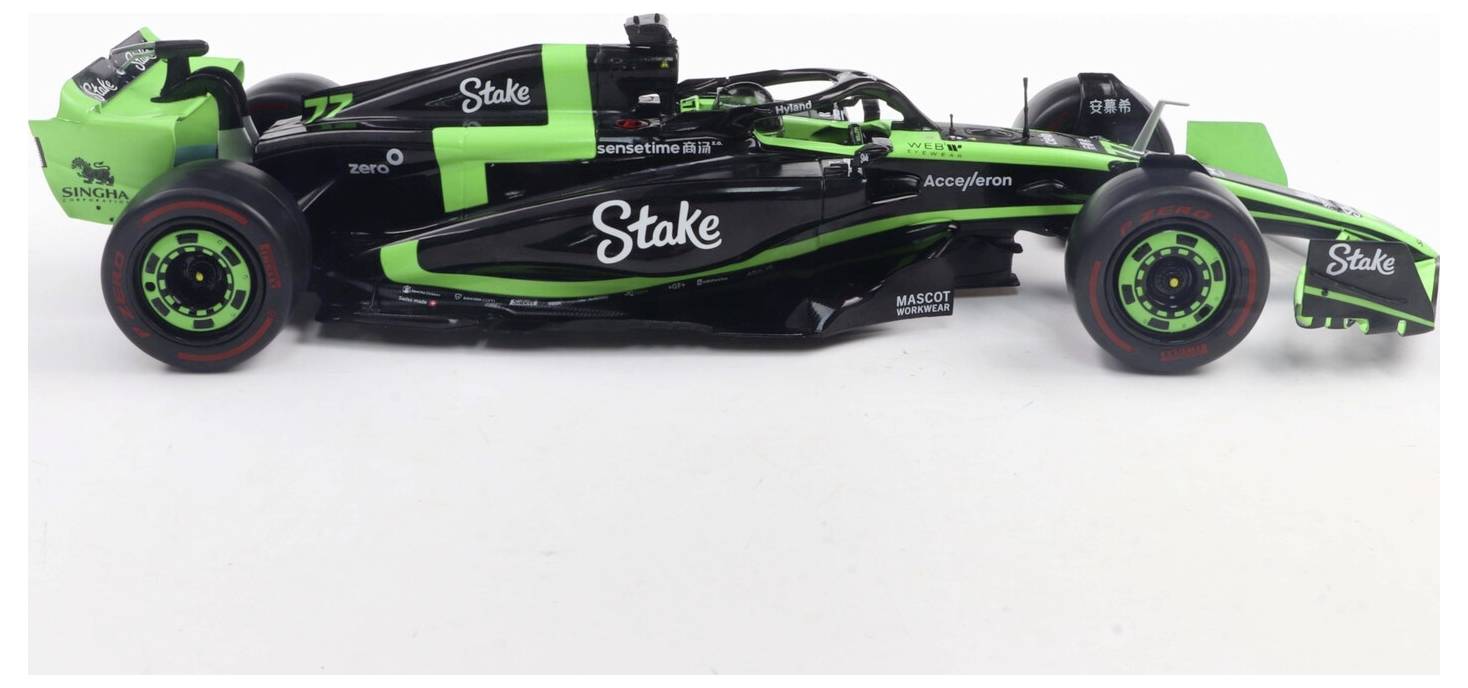 Černý a zelený Formula 1 závodní vůz s různými logy sponzorů, který vykazuje elegantní aerodynamický design a nízkoprofilové pneumatiky.