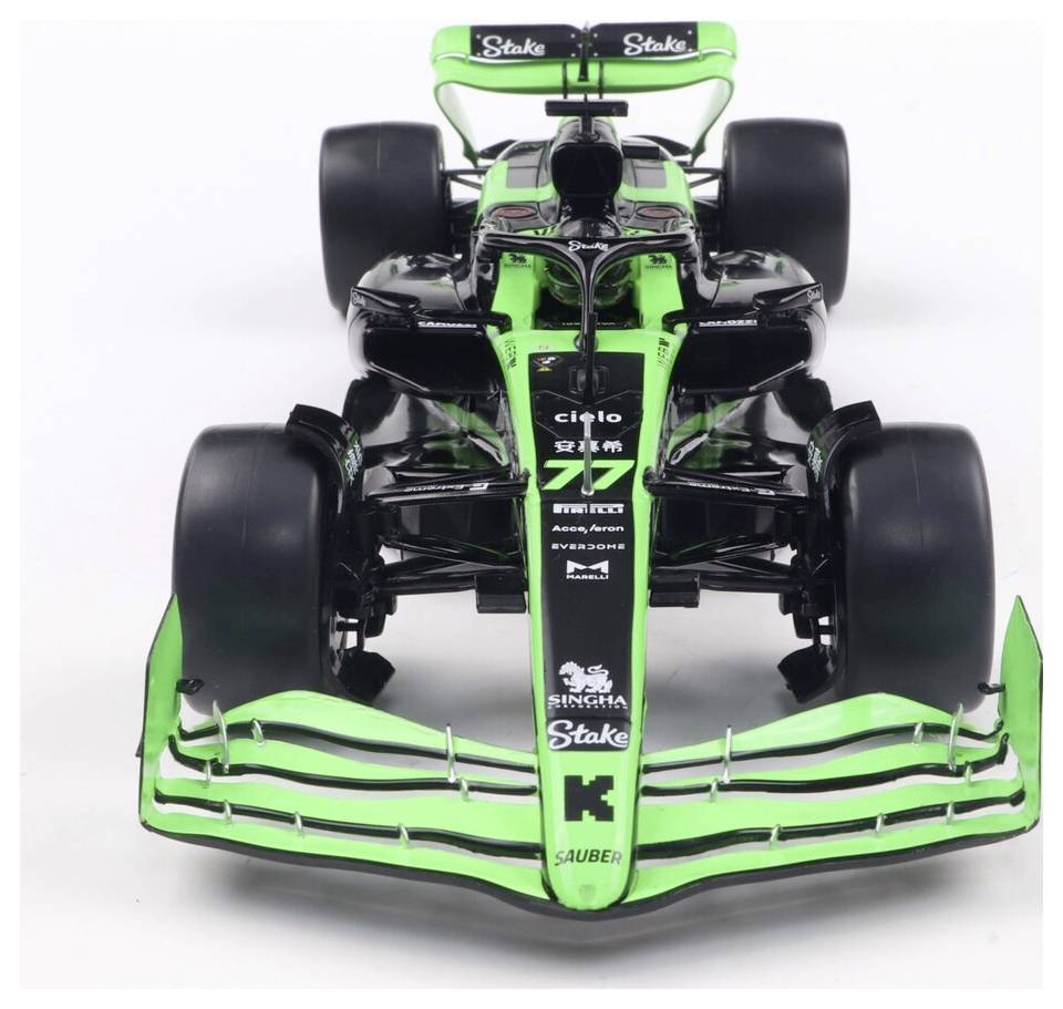Model formule 1 v zelené a černé barvě, s propracovanými aerodynamickými designovými prvky a logy sponzorů, pohled zepředu.