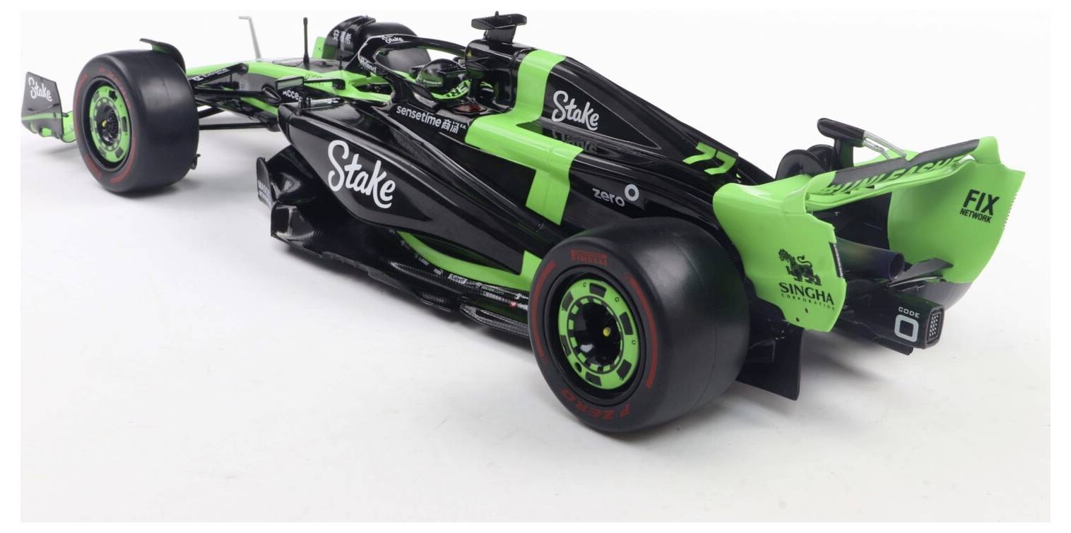 Zelený a černý formulový vůz F1 s logy sponzorů, vykazující aerodynamický design a obtékané tvary, na bílém pozadí.