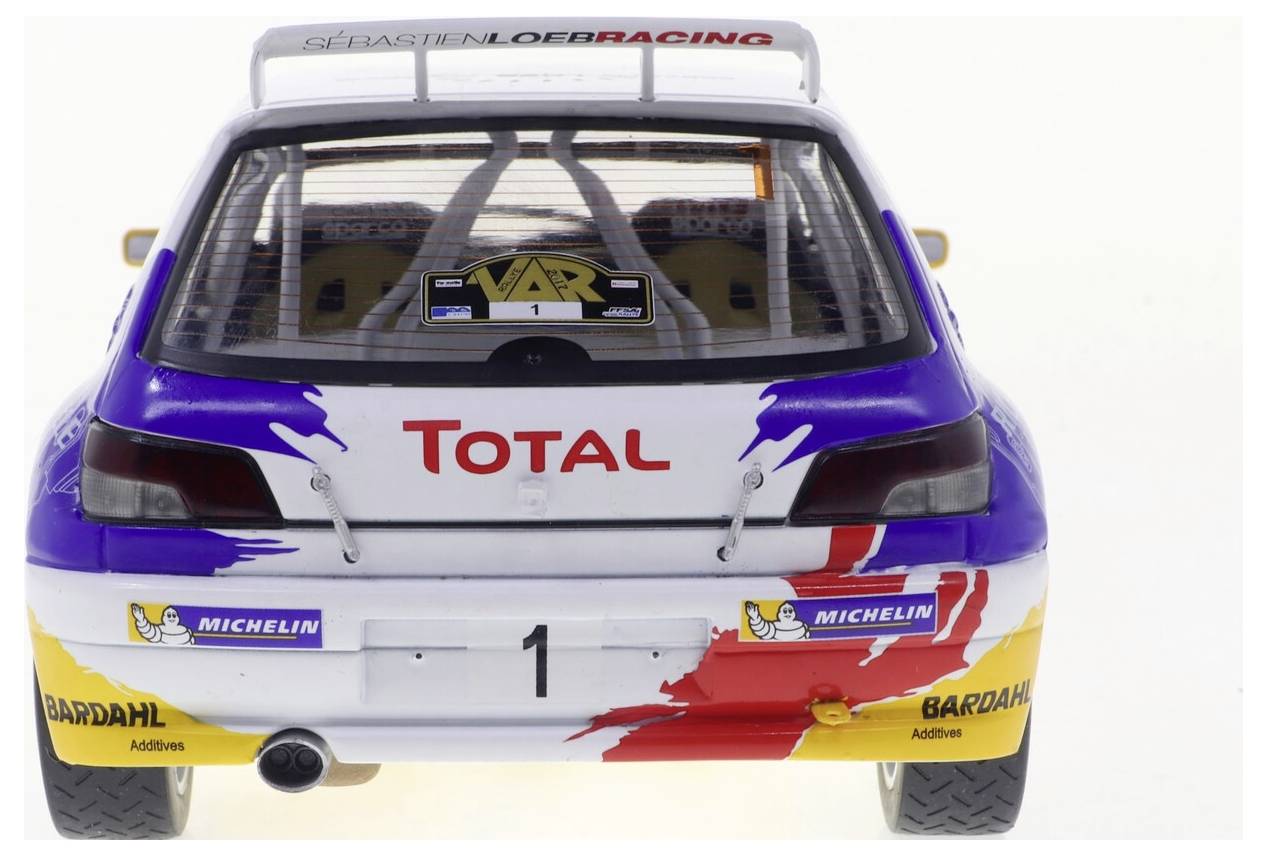 Pohled zezadu na rally automobil s výrazným brandingem „Total" a „Michelin". Vůz má barevné lakování a zobrazené číslo „1".