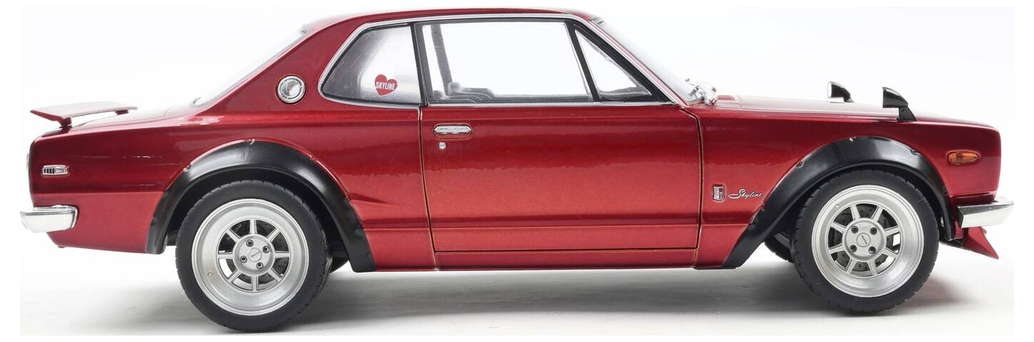 Červené vintage auto s elegantním designem je pohledáno z boku, přičemž ukazuje svou klasickou karoserii, lesklý lak a jedinečné ráfky kol.
