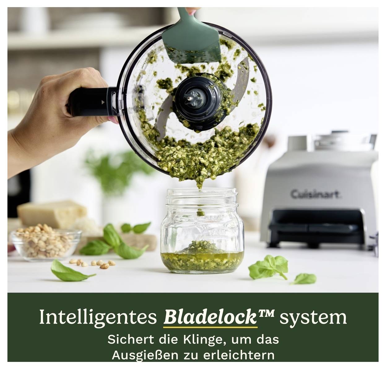 Ruka nalévá pesto z nádoby food processoru do sklenice. Text dole: "Inteligentní systém Bladelock™ zajišťuje čepel, aby usnadnil nalévání".