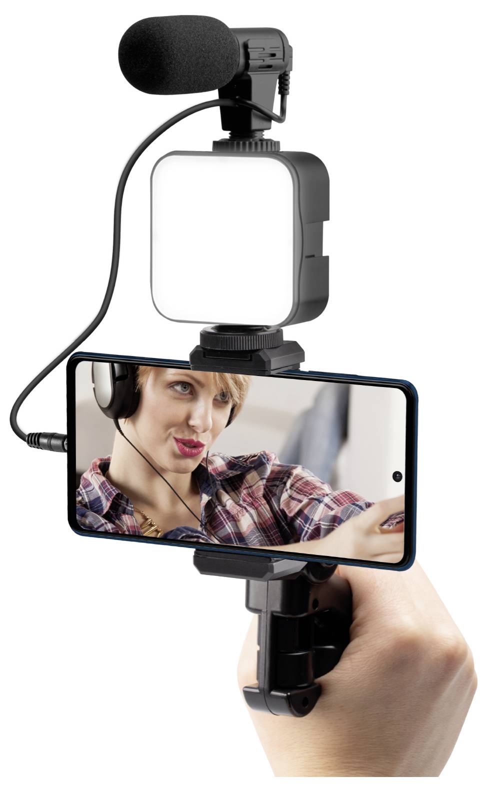 Přenosné zařízení pro smartphone s mikrofonem a osvětlením se používá k video nahrávání, přičemž na displeji telefonu je vidět osoba v sluchátkách.
