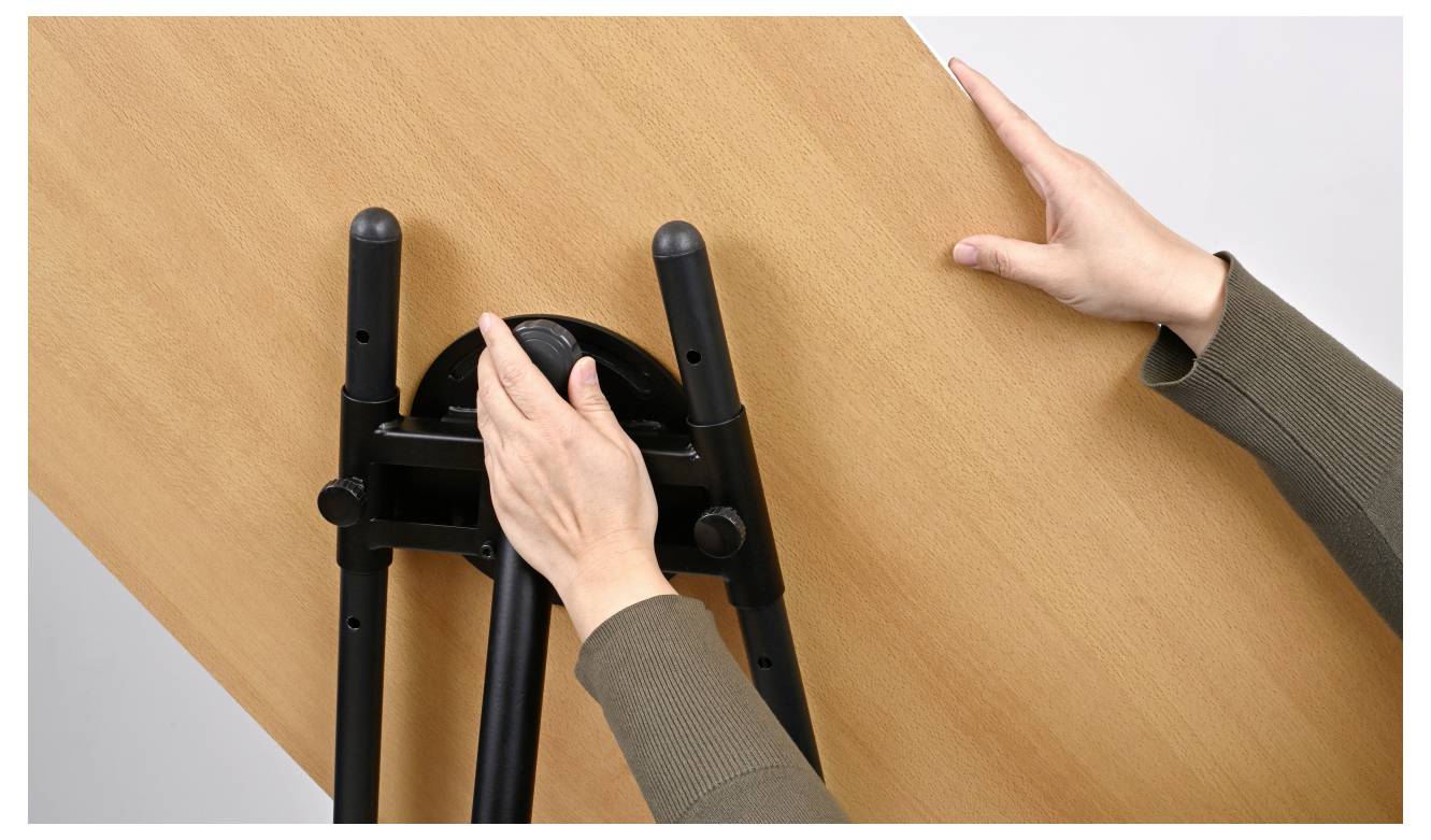 Ruce upravující povrch stolu s mechanismem pro naklápění.
