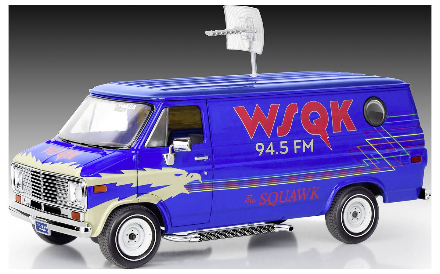 Modrý dodávkový vůz s logy 'WSQK 94.5 FM' a 'The Squawk', který zobrazuje grafiku orla a má anténu na střeše, reprezentující propagační vozidlo rozhlasové stanice.